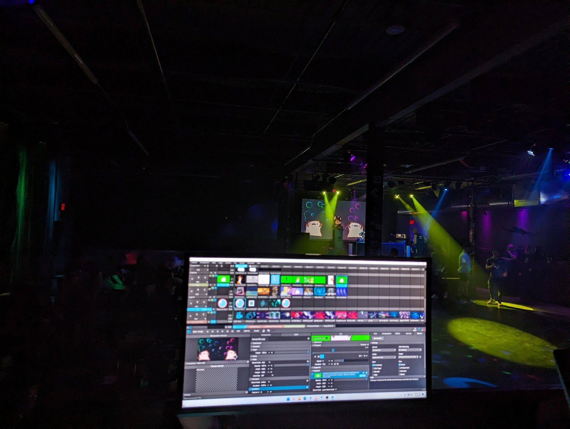 A photo from the Front of House riser at Crucible in Madison, WI showing my computer running Resolume with the stage in the background showing the output on the projector while setting up for FANG.