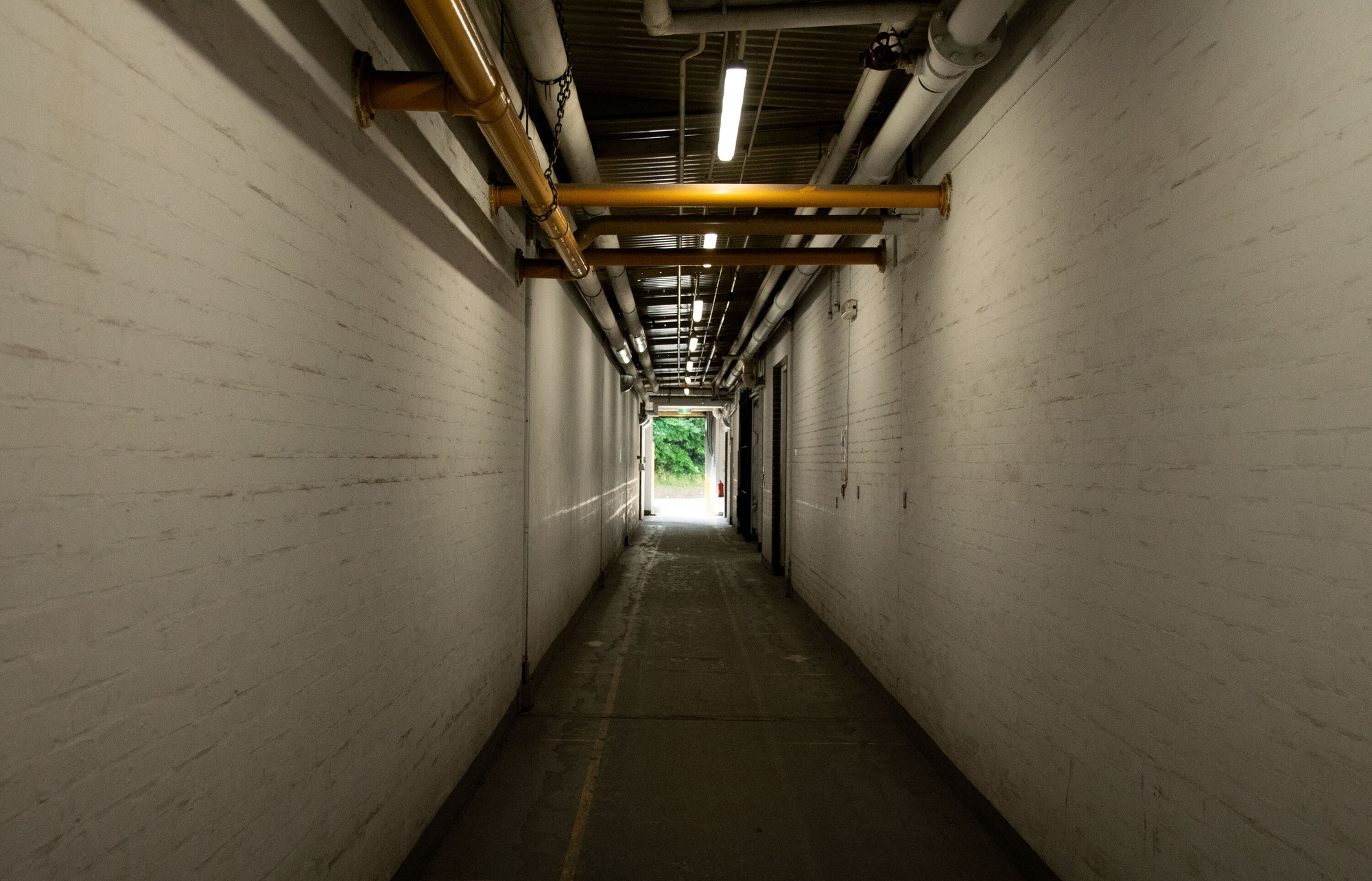 Empty corridor in the wallpaper factory looking towards an open door.