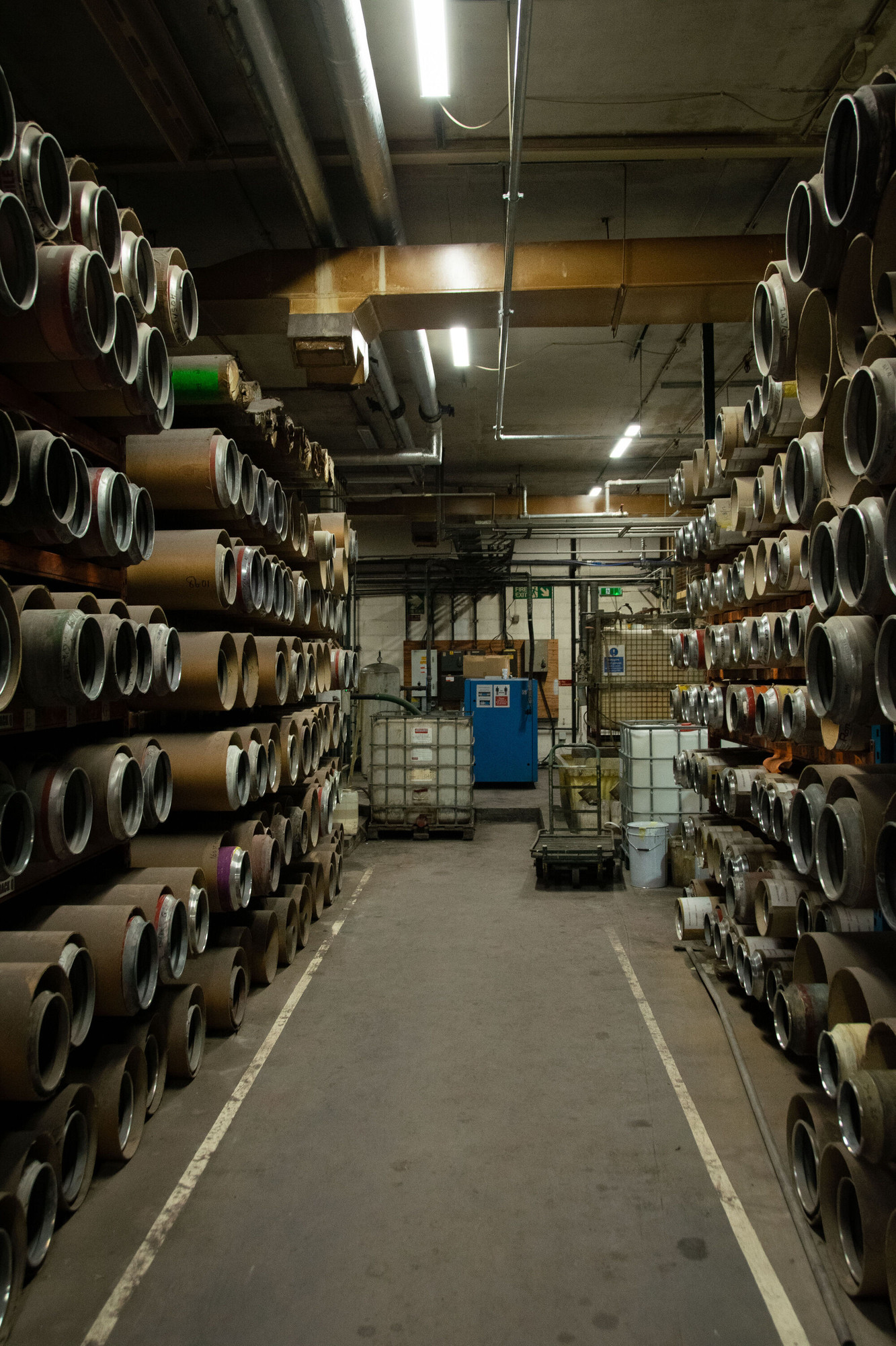 Inside view of the manufacturing building. Large tubes on shelving.