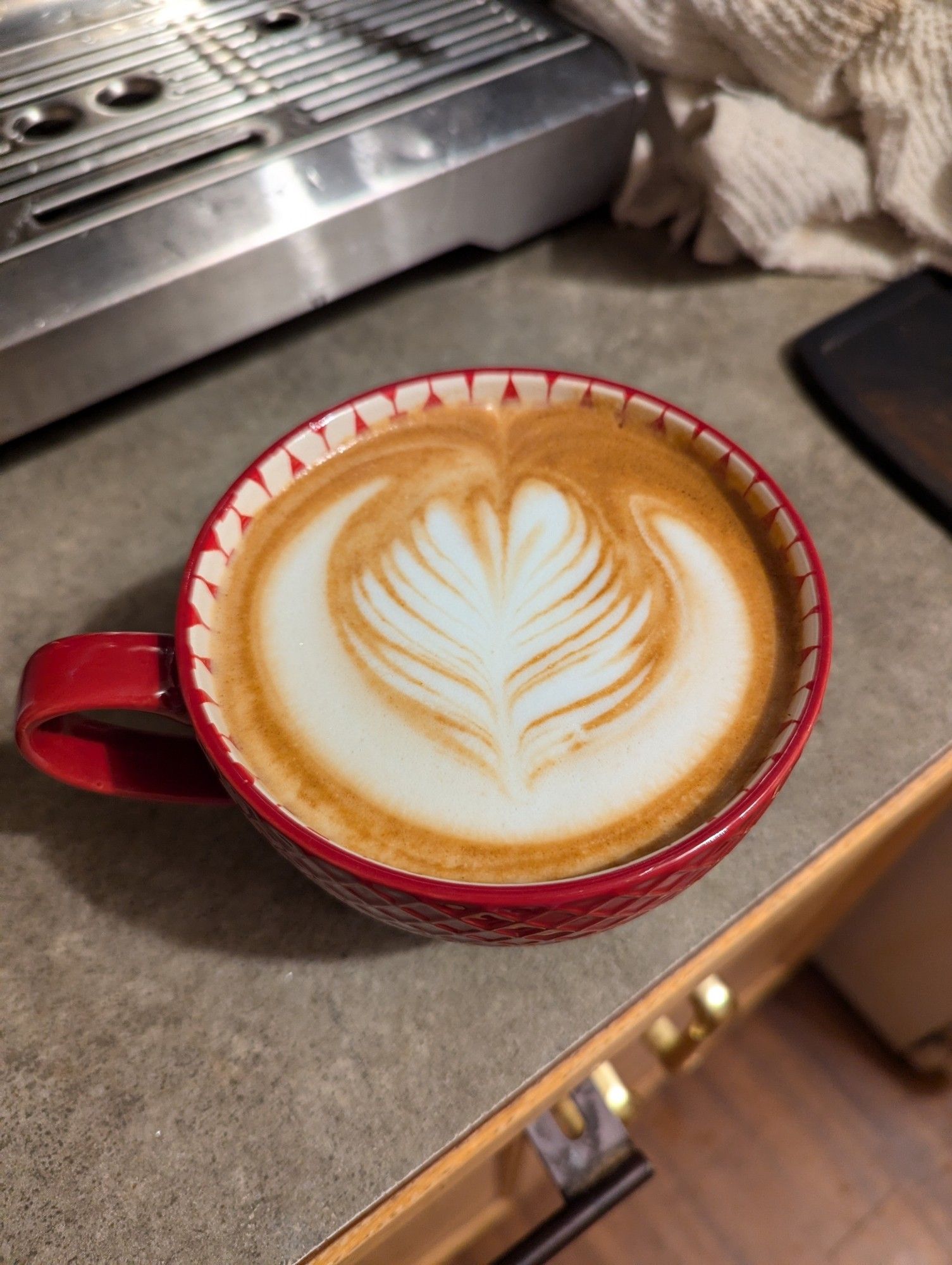 A latte poured with rosetta latte art.