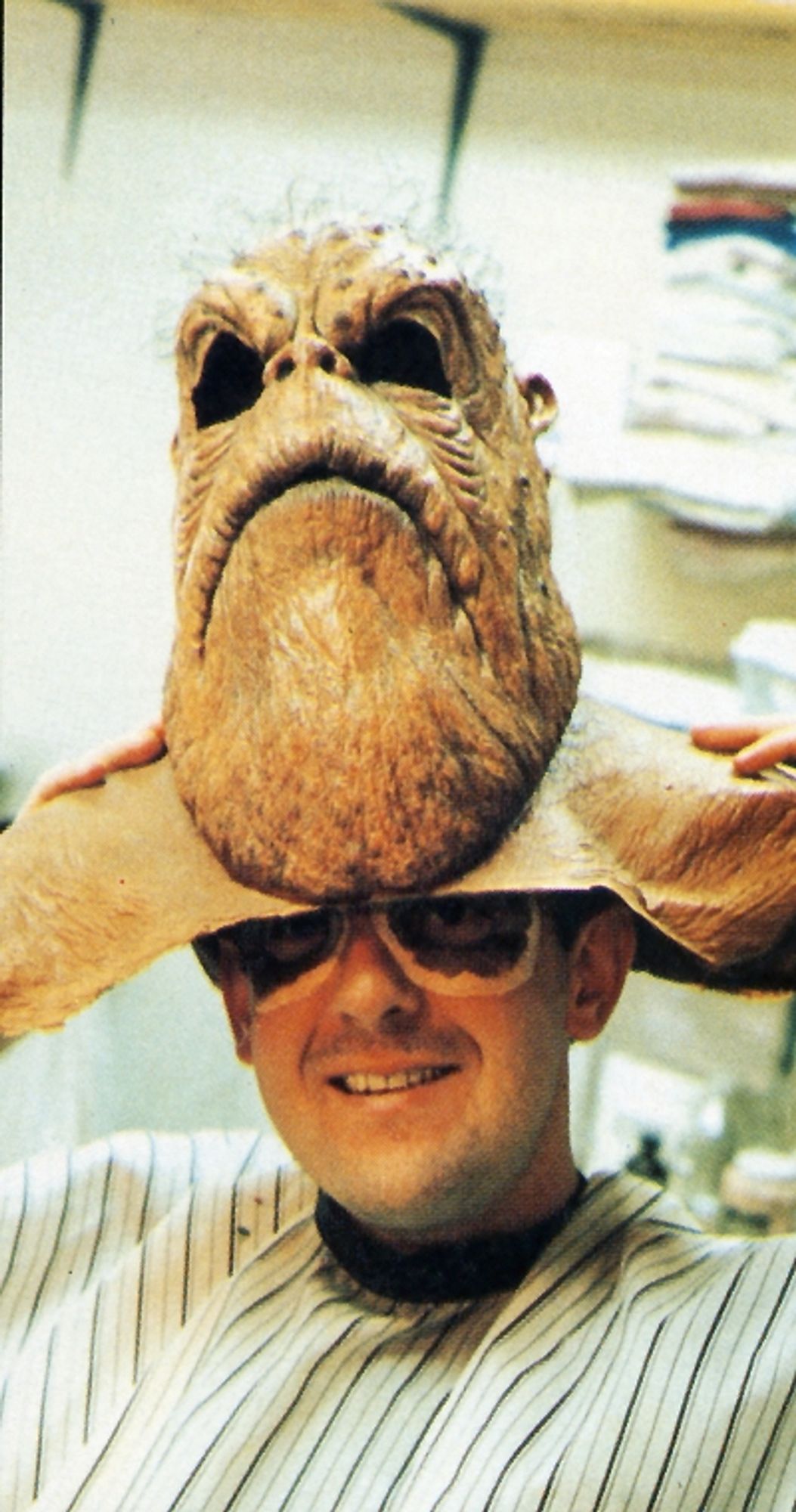 Morn actor Mark Allen Shepherd of DS9 lifts his mask to reveal his face