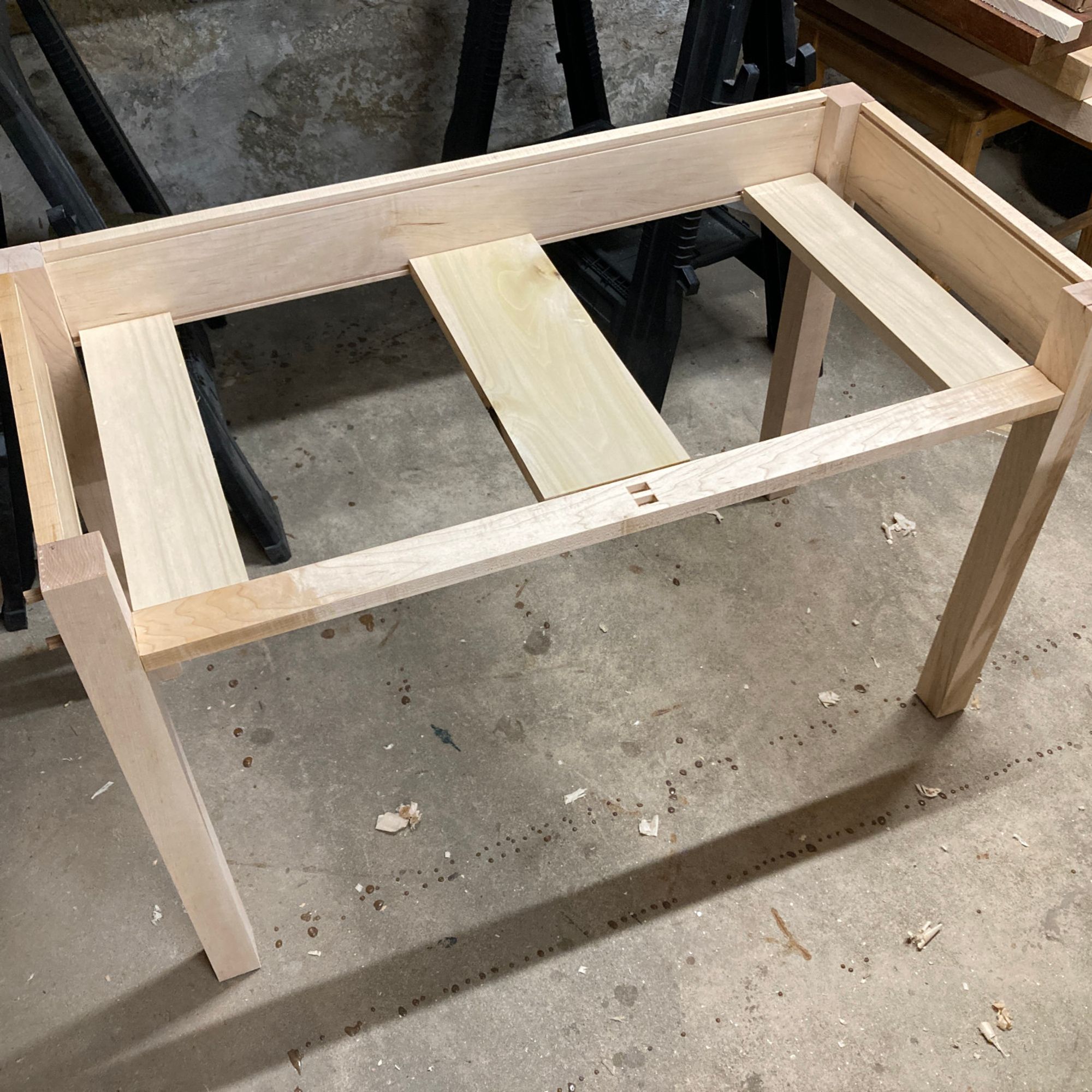 The base of a desk, fully assembled and glued up. The wood is all hard maple. The stretchers have grooves in them I cut with a no48 tongue and groove plane. The bottom grooves are for the bits that hold up the drawers, and the top grooves are for the expansion fasteners that hold the base to the top.