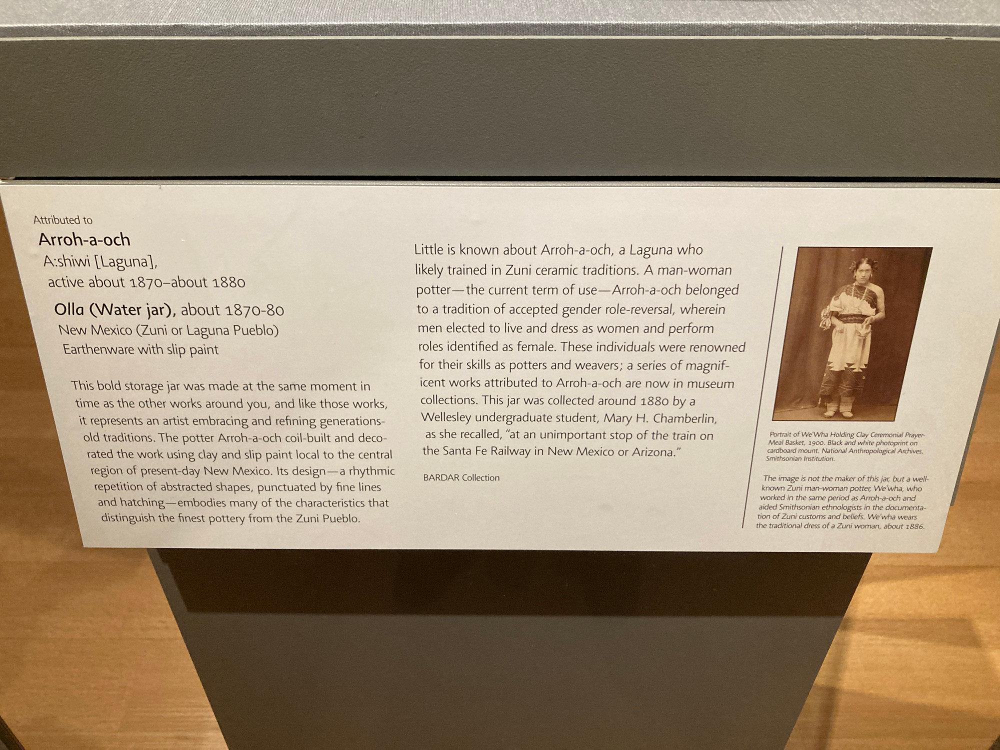 The museum’s caption for the pot:
Attributed to Arroh-a-och
Active about 1870-80

Ella (water Jar) about 1870-80
New Mexico (Zuni or Laguna Pueblo) 
This bold storage jar was made at the same moment in time as the other works around you, and like this works, it represents an artist embracing and refining generations-old traditions. The potter Arroh-a-och coil-built and decorated the work using clay and slip paint local to the central region of present-day New Mexico. Its design—a rhythmic repetition of abstracted shapes, punctuated by fine lines and hatching—embodies many of the characteristics that distinguish the finest pottery from the Zuni Pueblo.

Little is known about Arroh-a-och, a Laguna who likely trained in Zuni ceramic traditions. A man-woman potter—the current term of use—Arroh-a-och belonged to a tradition of accepted gender role-reversal, wherein men elected to live and dress as women and perform roles identified as female. These individuals were renowned for their skills as potters and weavers; a series of magnificent works attributed to Arroh-a-och are now in museum collections. This jar was collected around 1880 by a Wellesley undergrad student, Mary H Chamberlin, as she recalled “at an unimportant stop of the train on the Santa Fe Railway in New Mexico or Arizona.” 
