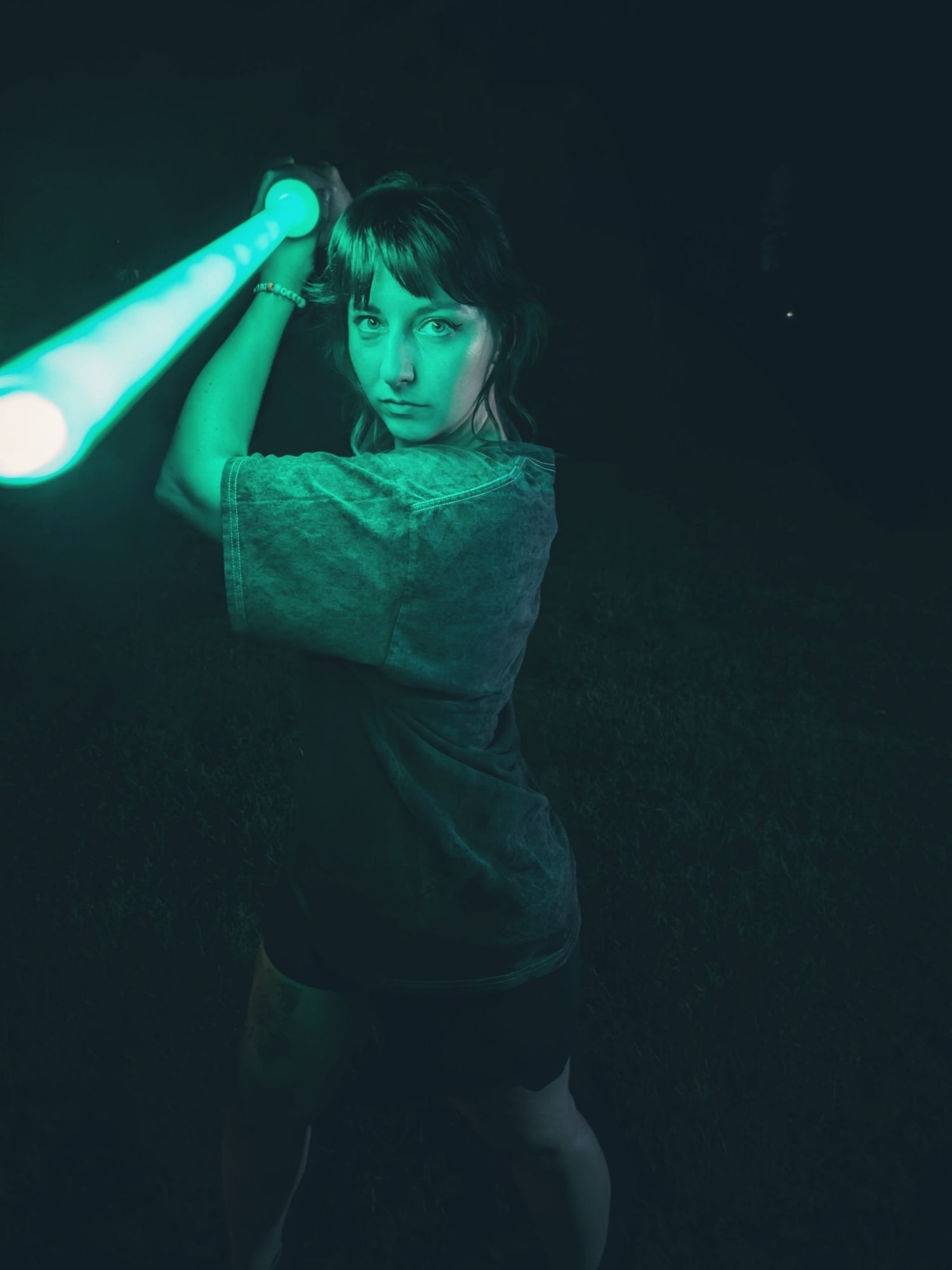 A photo of me holding a green light saber above my head and looking at the camera