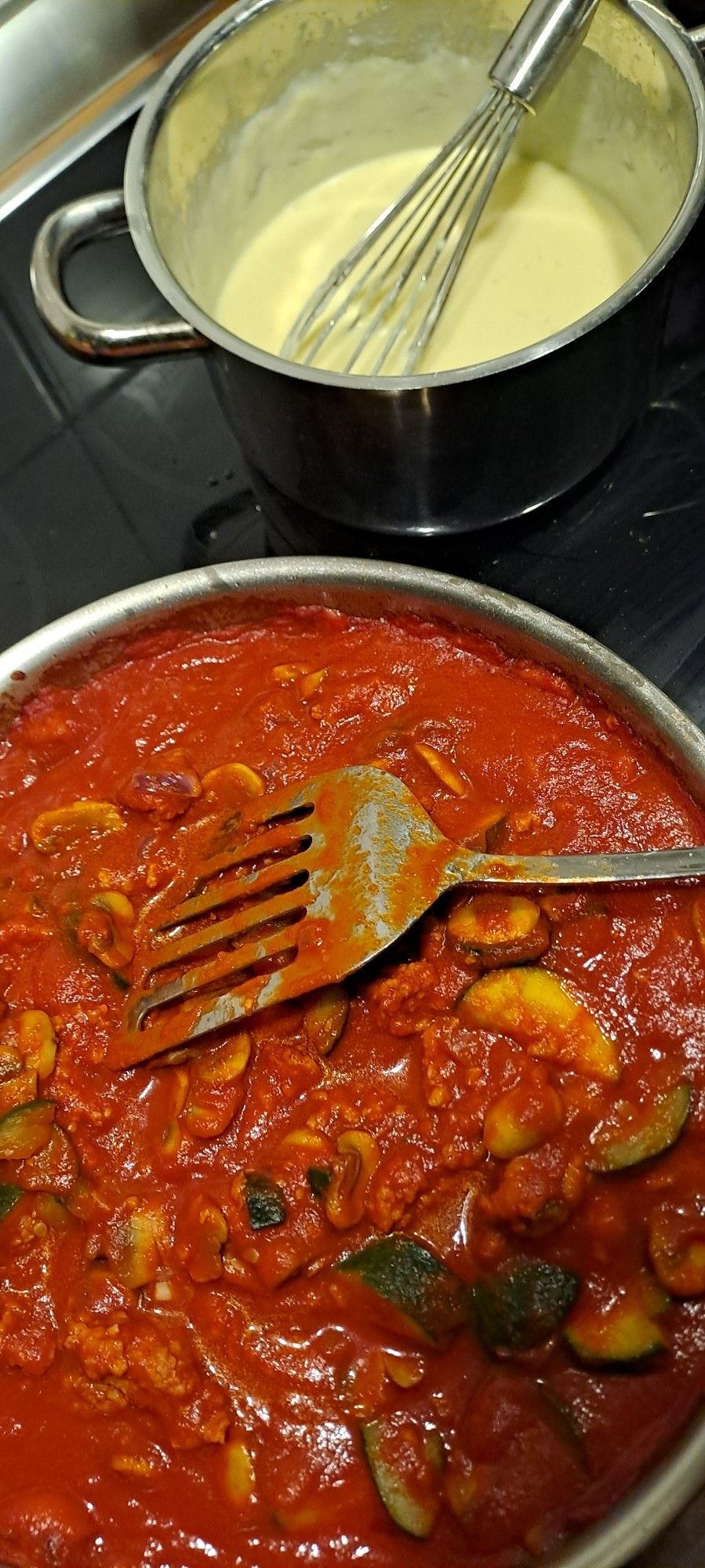 Tomatensoße in der Pfanne und bechamel im Topf daneben