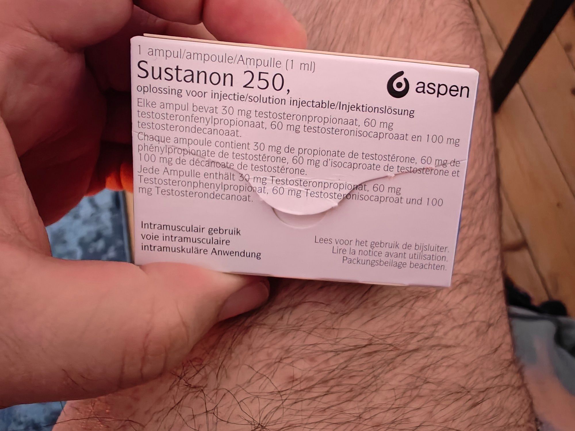 Me holding a box containing the medicine Sustanon, testosterone replacement therapy. My hairy leg is there, waiting for injection.