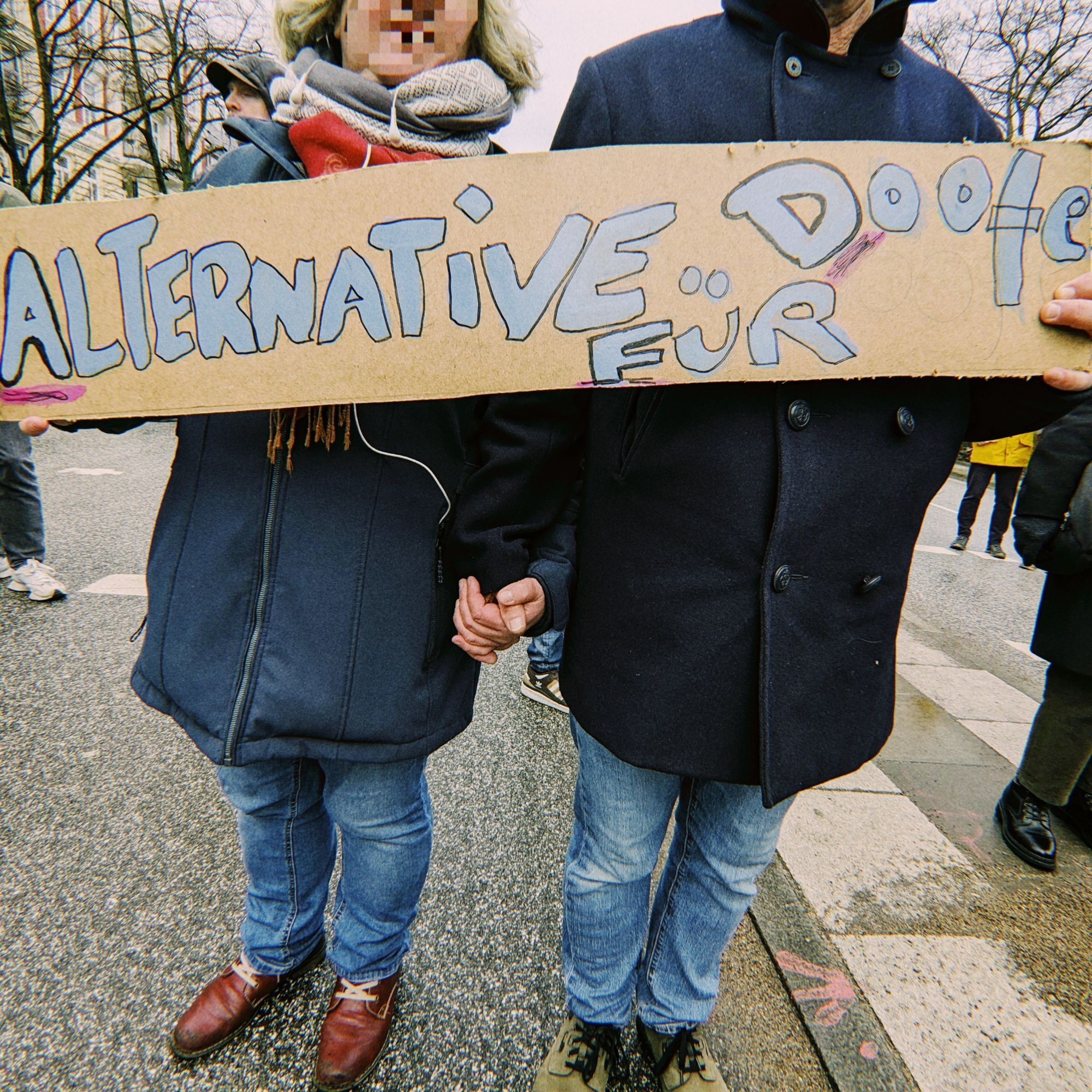 Ehepaar hält Schild mit der Aufschrift: "Alternative für doofe."