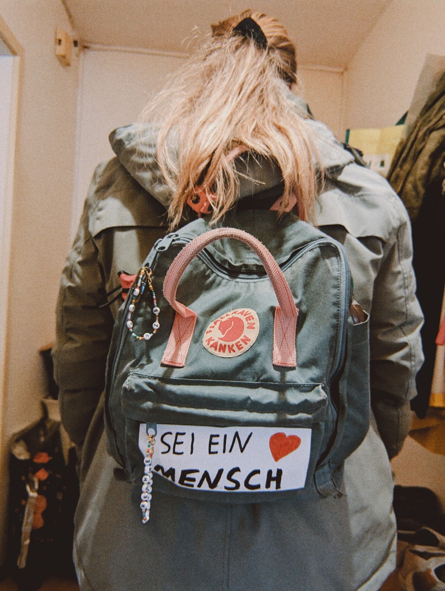 Rucksack mit einem Schild auf dem steht: "sei ein Mensch."