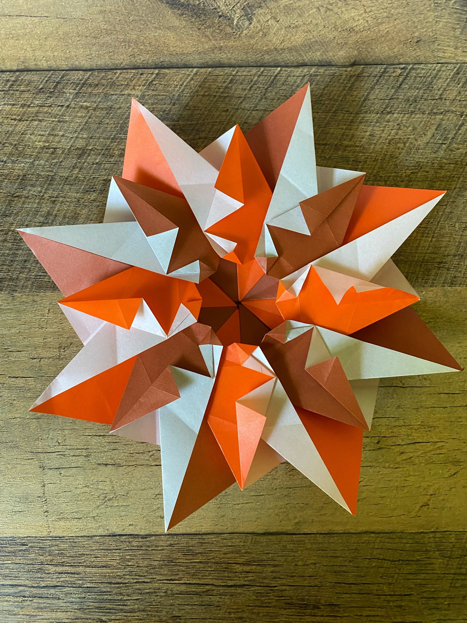 Eight-piece modular “mandala” alternating orange and brown kami paper.