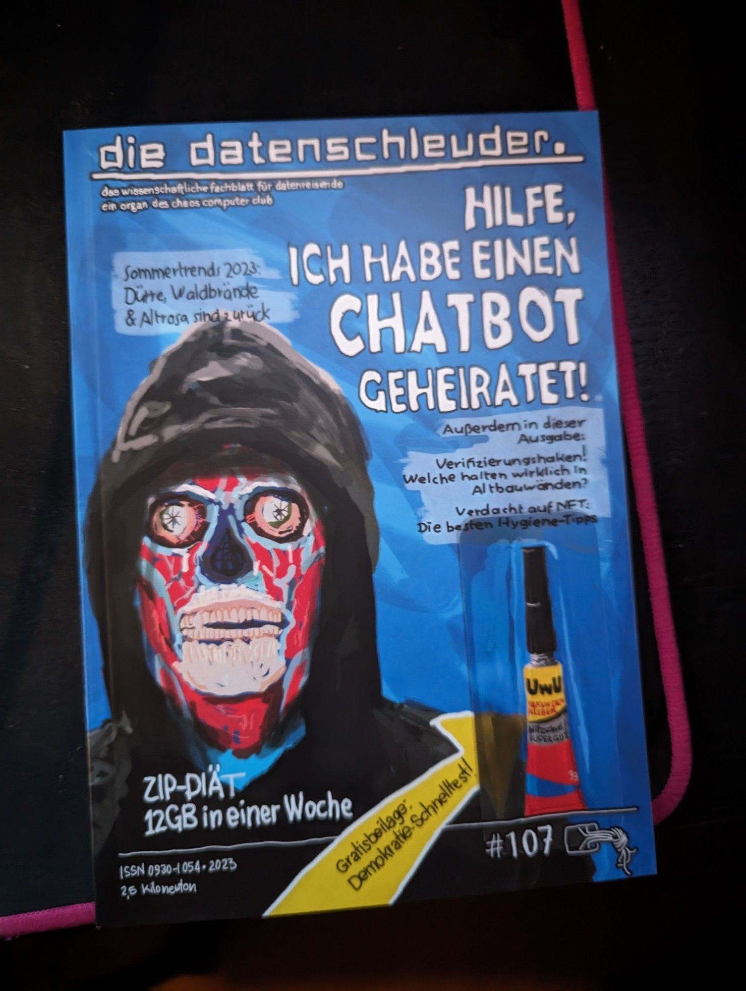 Ausgabe von "Die Datenschleuder" des Chaos Computer Club. Auf dem Titelbild ist eine Zeichnung einer Person in schwarzem Hoodie zu sehen, die künstlerisch ausgeschmückt wurde (keine Haut, aber farbiger darunter). Außerdem eine Tube UwU Sekundenkleber und etwas Text. Ganz groß geschrieben steht: "Hilfe, ich habe einen chatbot geheiratet!"