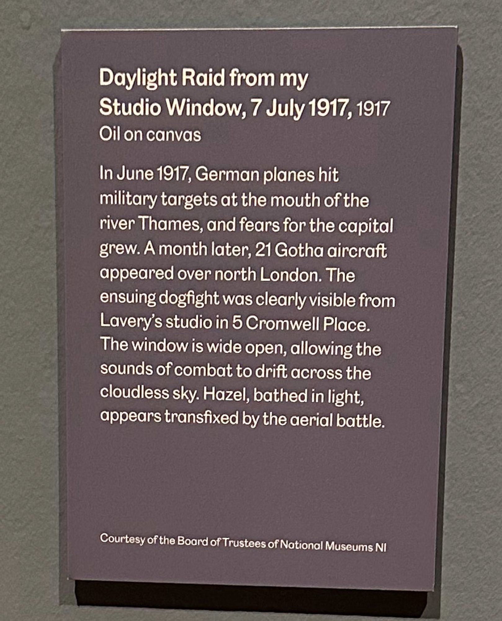 Gallery label text: Daylight Raid from my
Studio Window, 7 July 1917, 1917
Oil on canvas
In June 1917, German planes hit military targets at the mouth of the river Thames, and fears for the capital grew. A month later, 21 Gotha aircraft appeared over north London. The ensuing dogfight was clearly visible from Lavery's studio in 5 Cromwell Place.
The window is wide open, allowing the sounds of combat to drift across the cloudless sky. Hazel, bathed in light, appears transfixed by the aerial battle.
Courtesy of the Board of Trustees of National Museums NI