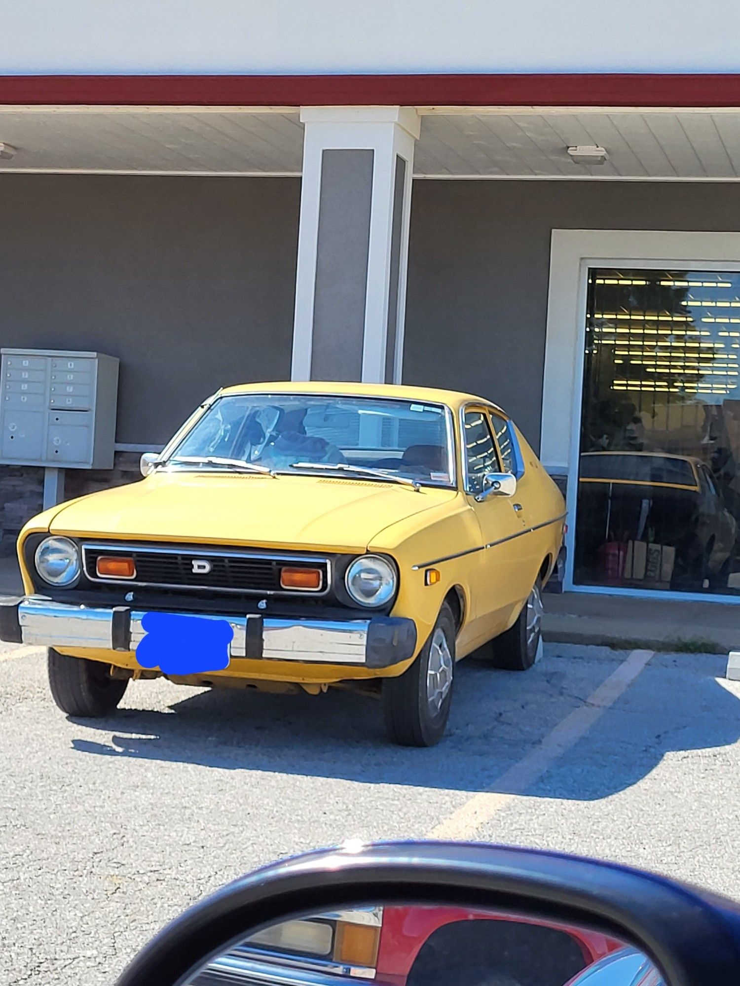 Side-angle shot of a yellow Datsun hatchback, not sure of the model