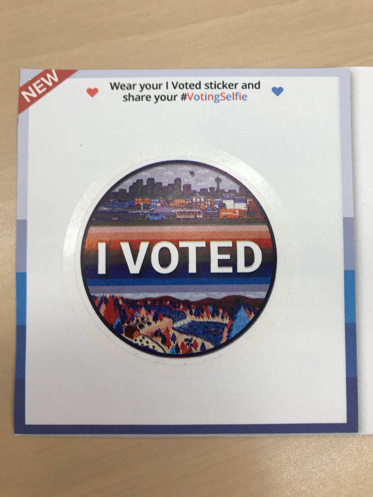 A circular “I Voted” sticker for Washington state, showing a Seattle skyline in the upper half and countryside below.