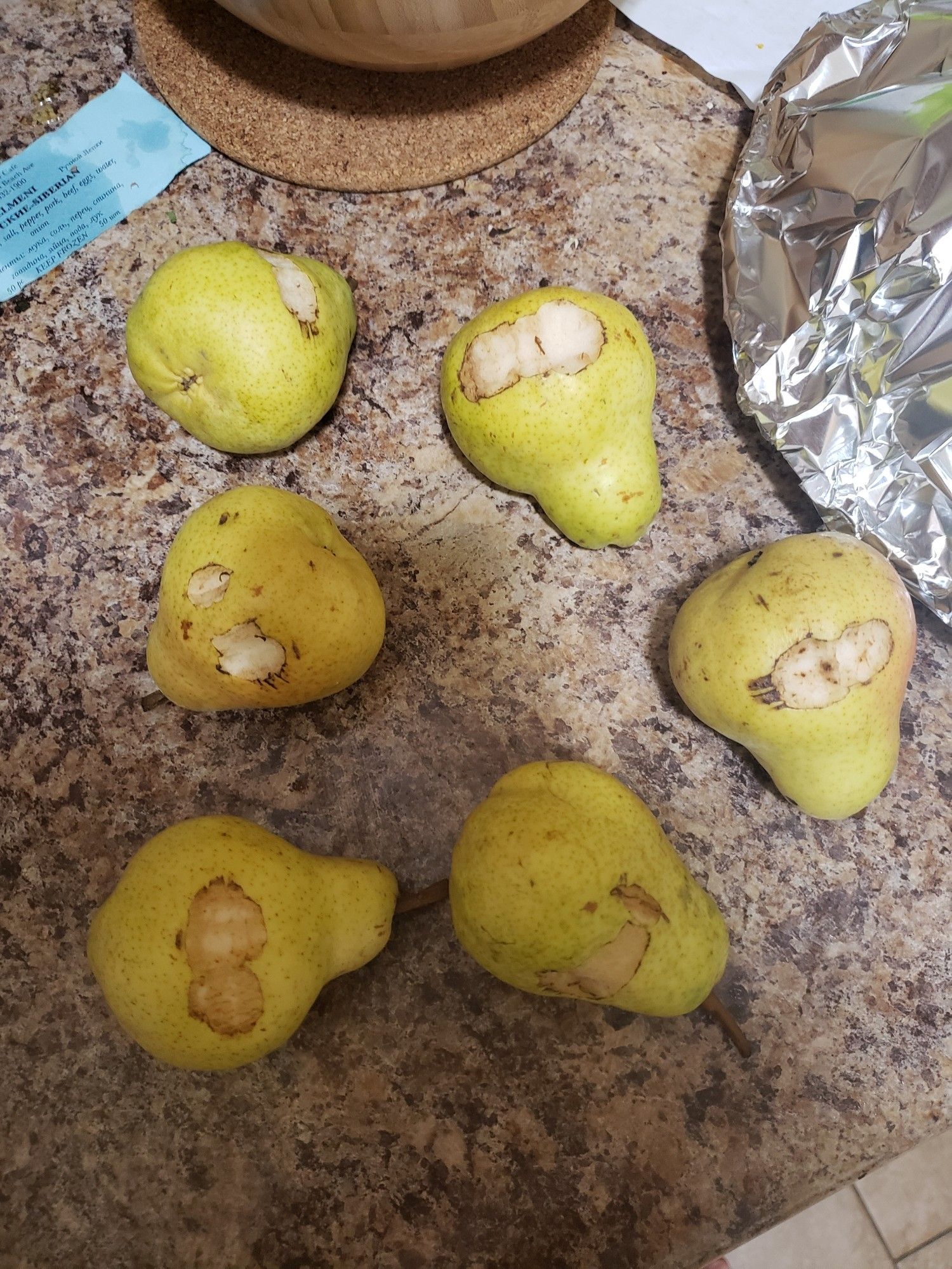 Six pears that have a small bite taken out of each