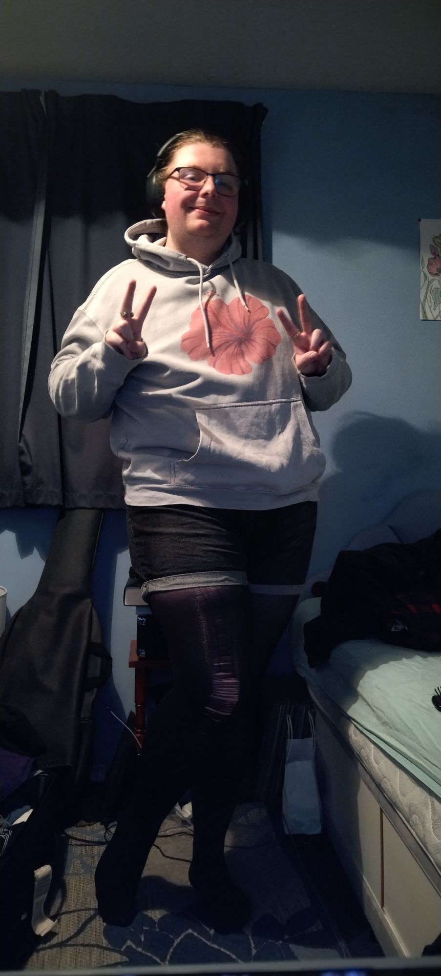 Me Wearing A Pink Hoodie With A Hibiscus, Cuffed Blue Denim Shorts, And Black Tights.