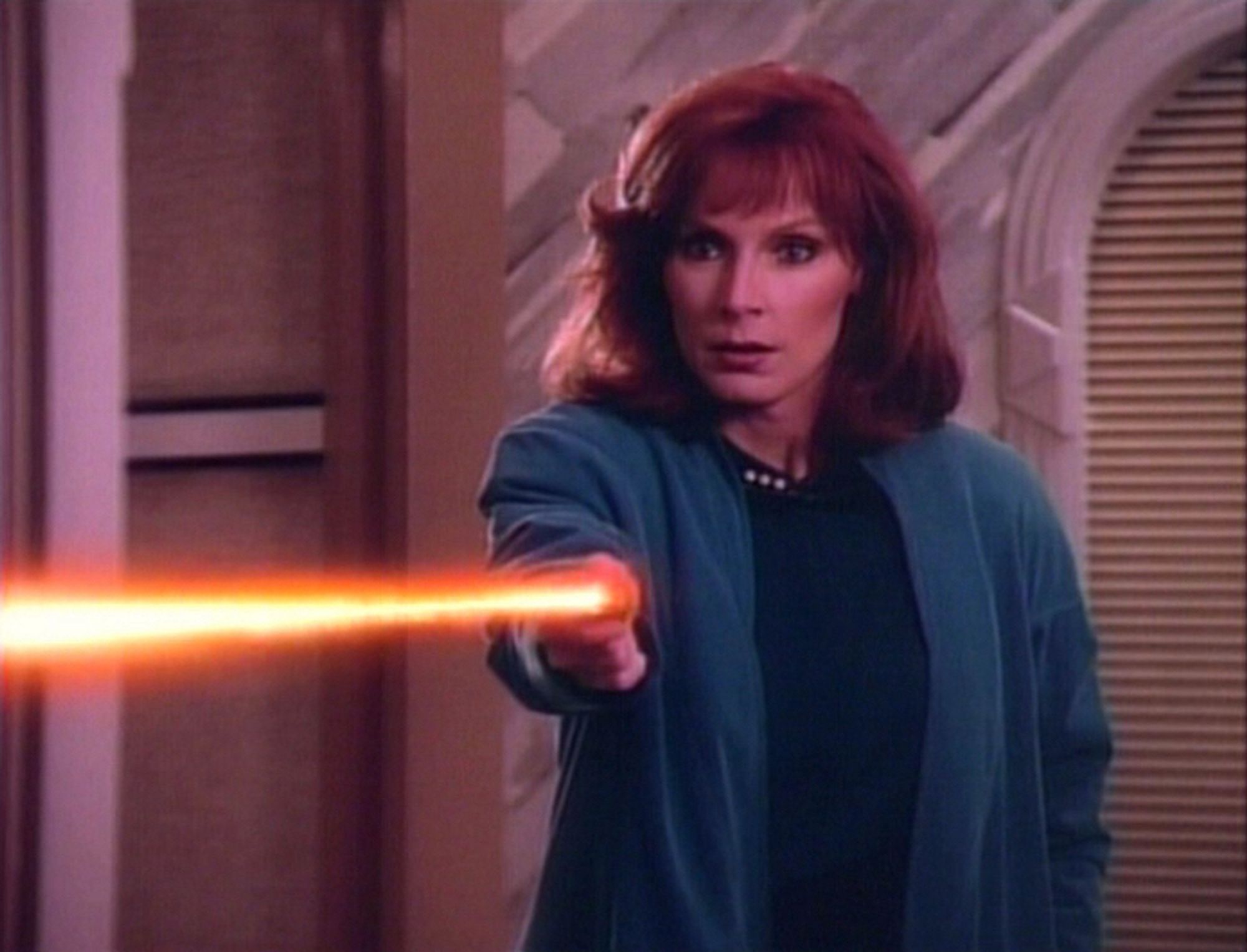 beverly crusher looking FIERCE firing a phaser toward screen left