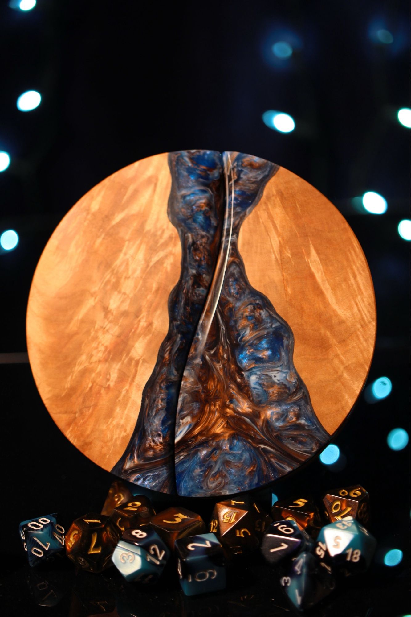 Round maple dice box with a channel of swirling blue and brass epoxy incorporated into the top