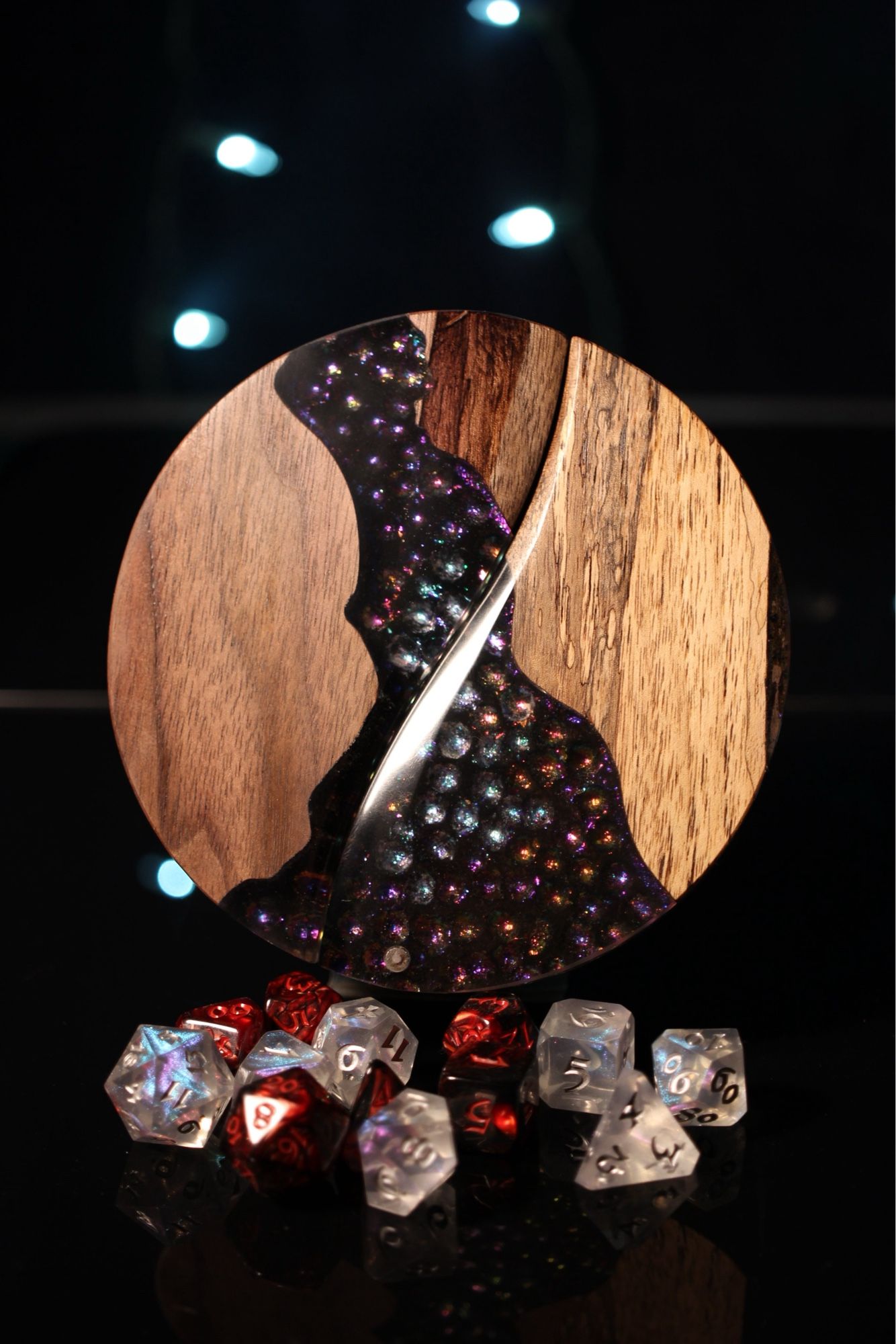 Round walnut dice box with a channel of iridescent cobblestones made from epoxy incorporated into the top