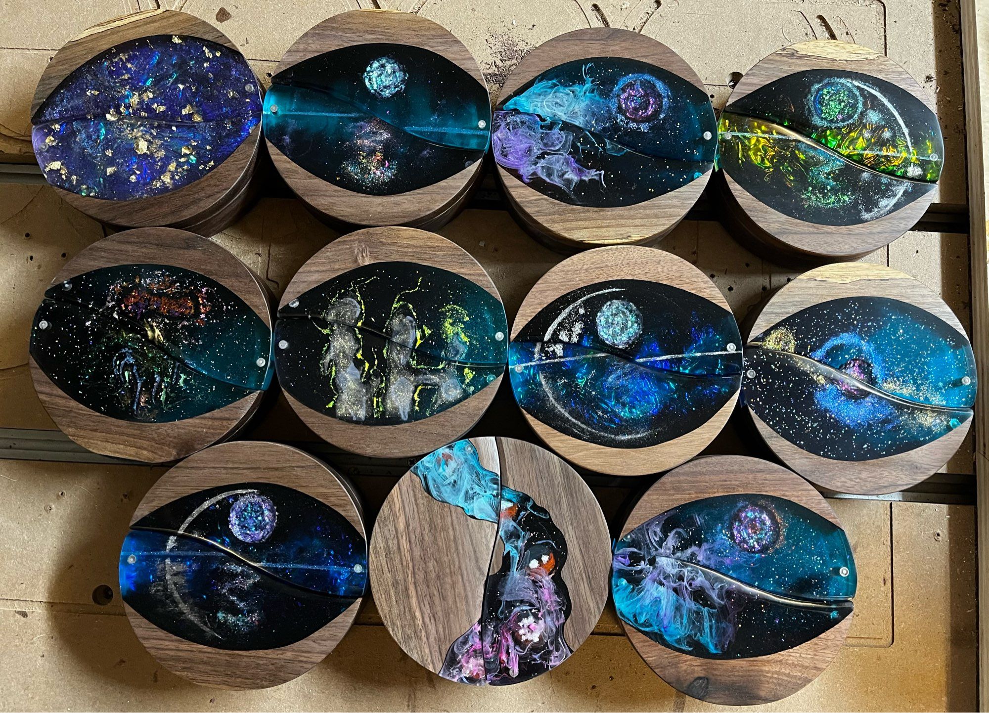 11 round dice boxes with different styles and colors of epoxy incorporated into the tops.