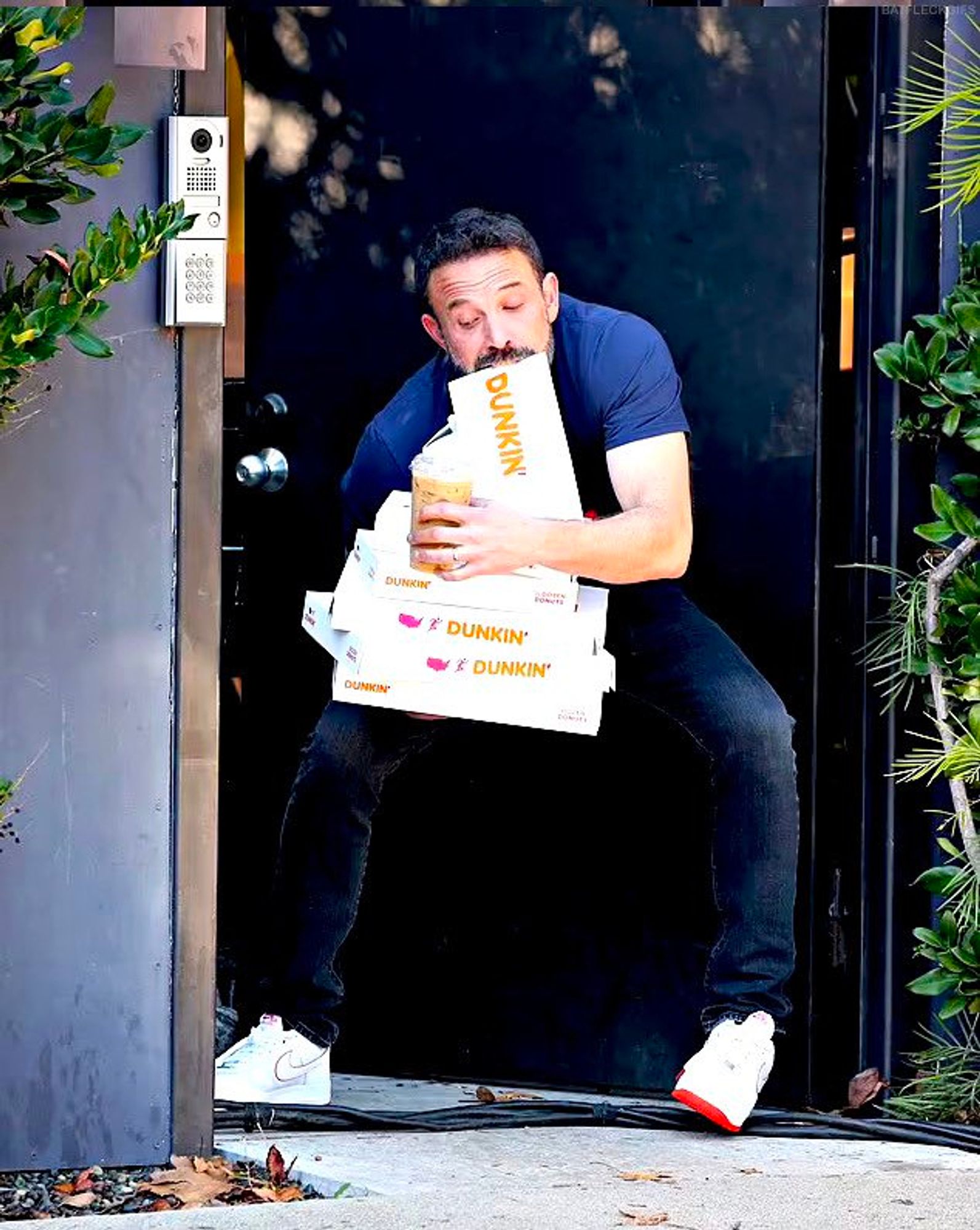 ben affleck with three boxes of dunkin, a bag of it in his teeth and an iced coffee. he's struggling.