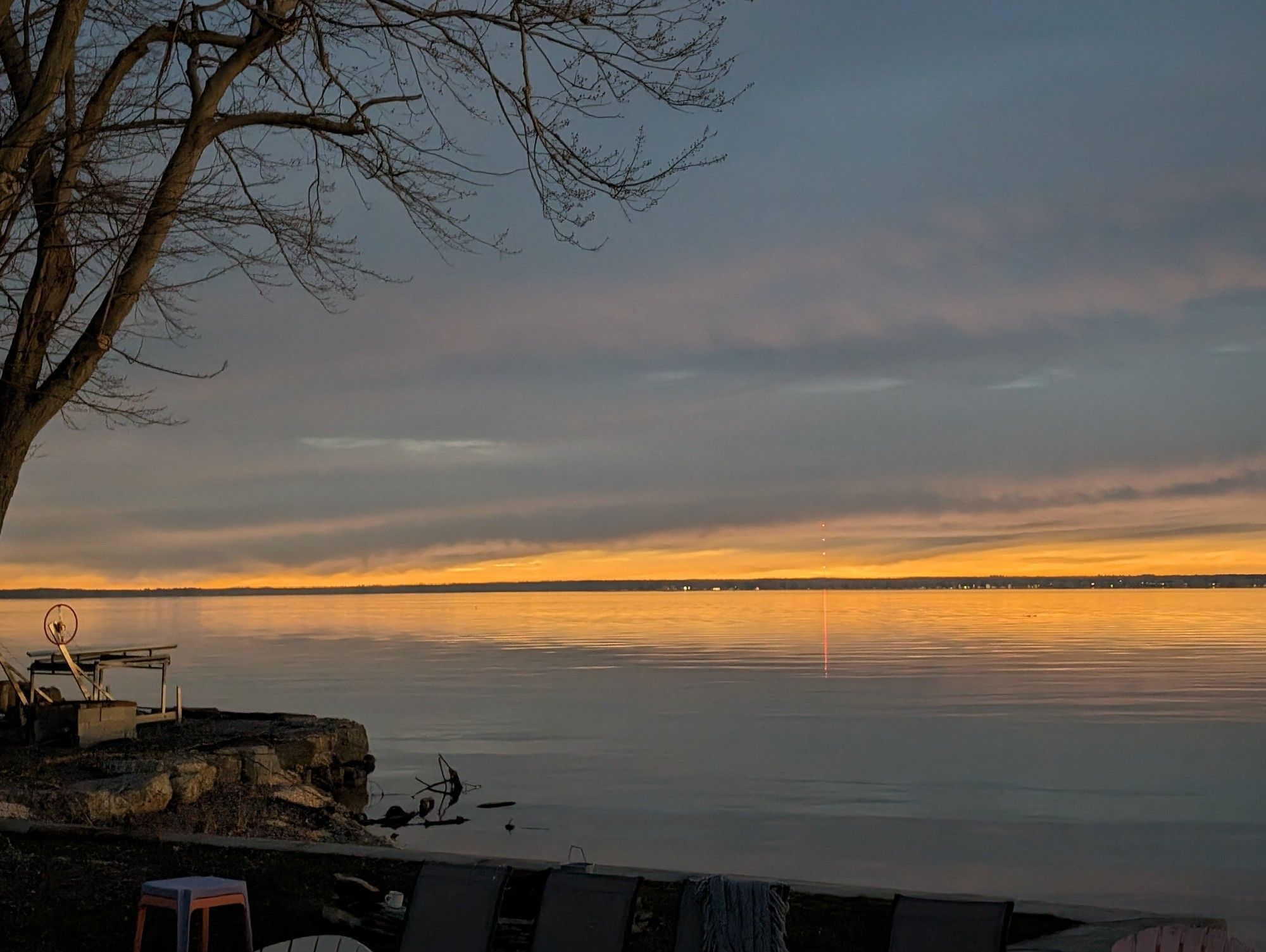 The sky is dark with a burning orange horizon over the water