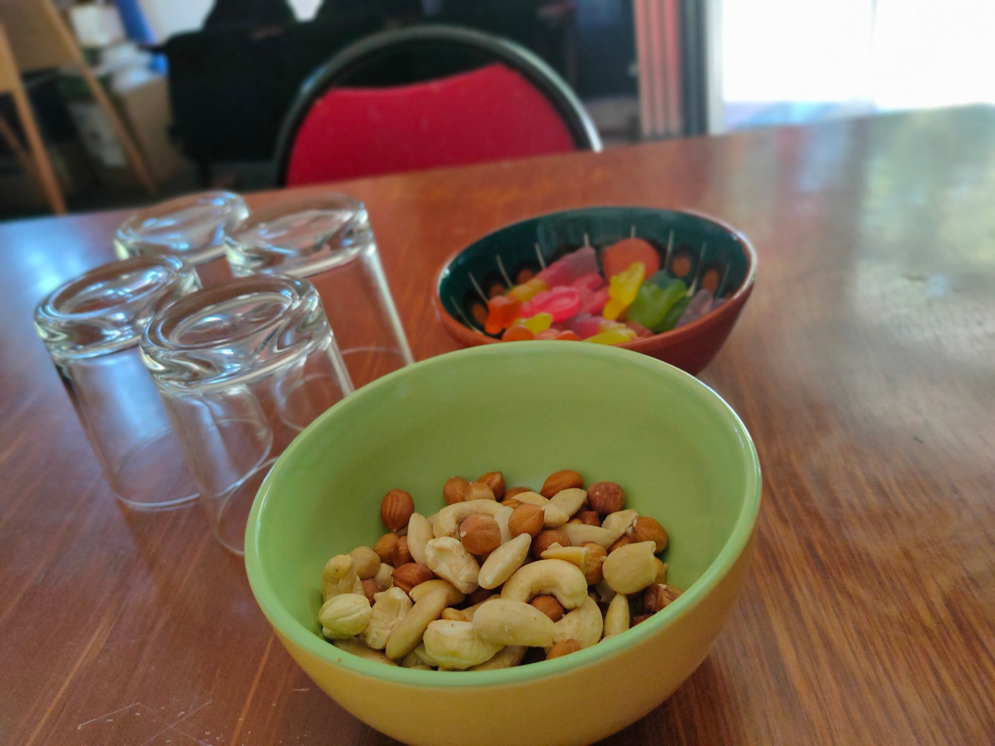 Ein Tisch. Auf ihm stehen zwei Schüssel mit Nüssen und Gummibärchen