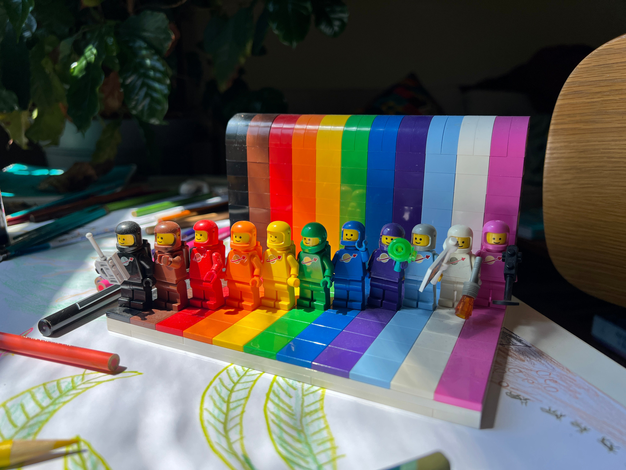 Lego Everyone is Awesome set with the minifigs replaced with Lego astronauts of the 1980s era in matching colors to the rainbow.
