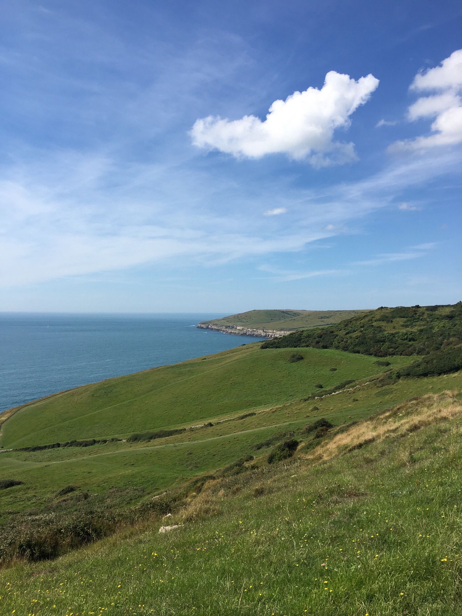 Dorset coastline near Dancing Ledge.  Land, sea and sky.  Some tiny coasteering enthusiasts in view