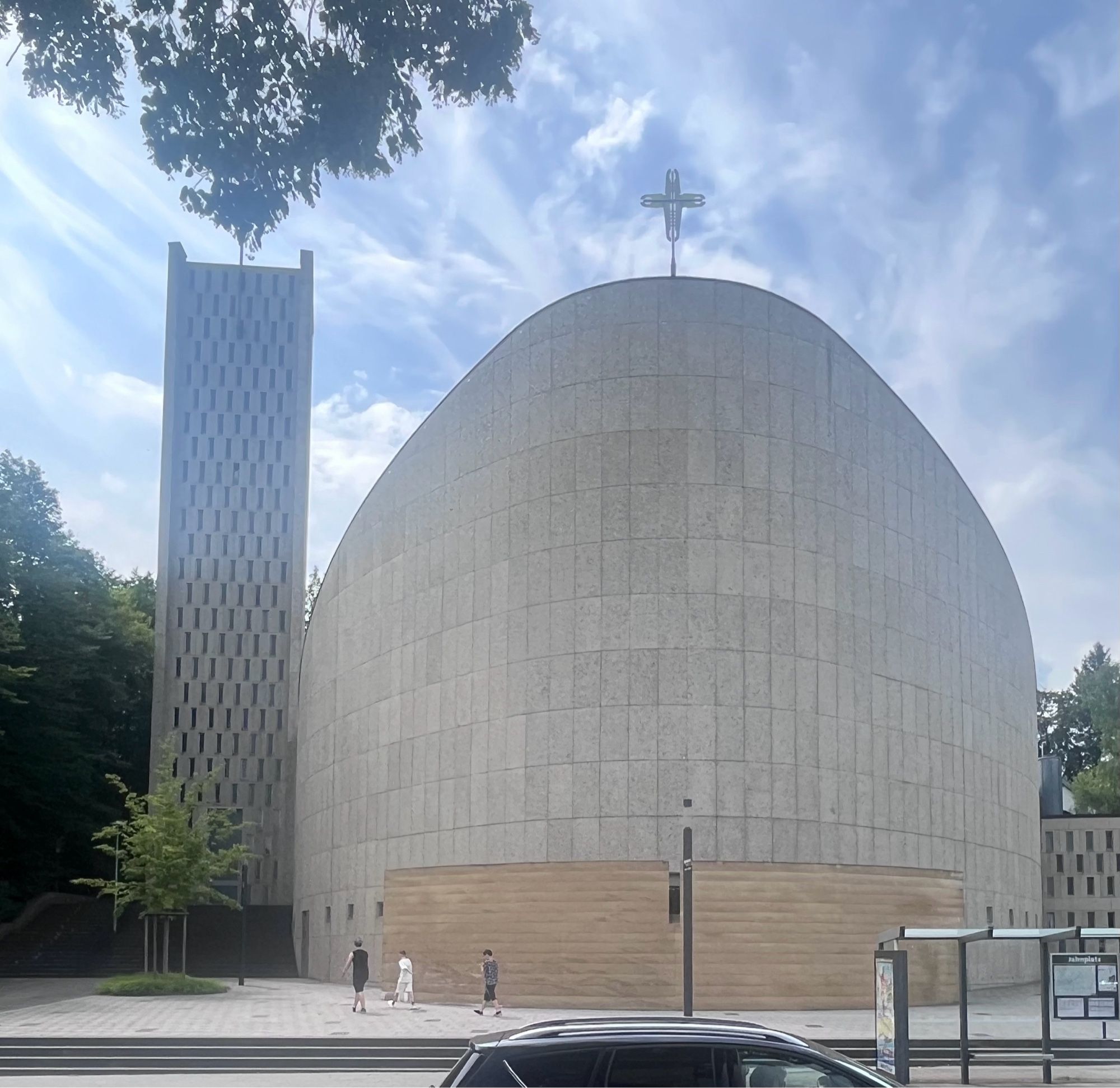 A curved church, now columbarium, dressed in concrete panels.