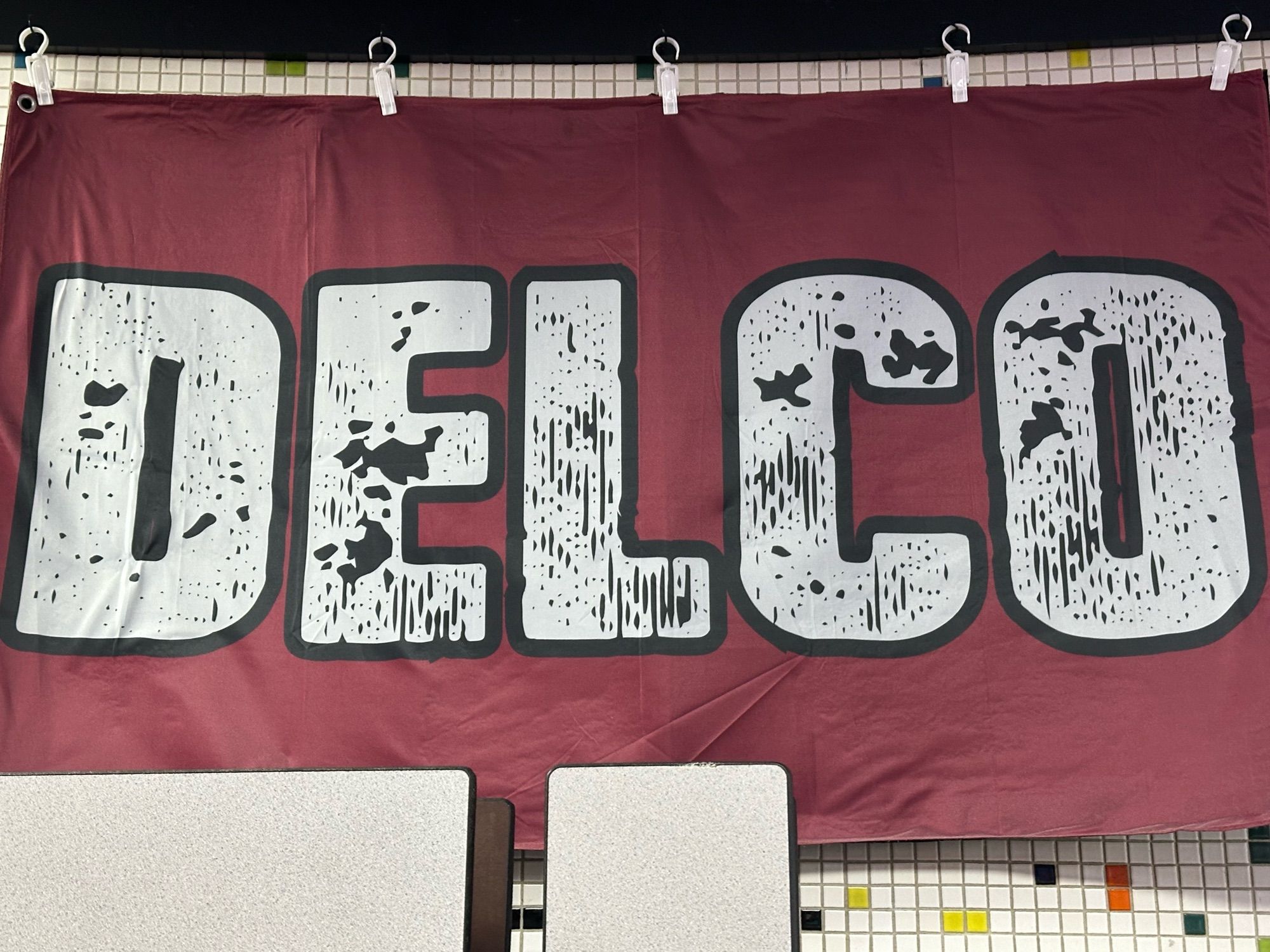 A flag hanging in a bowling alley that says DELCO