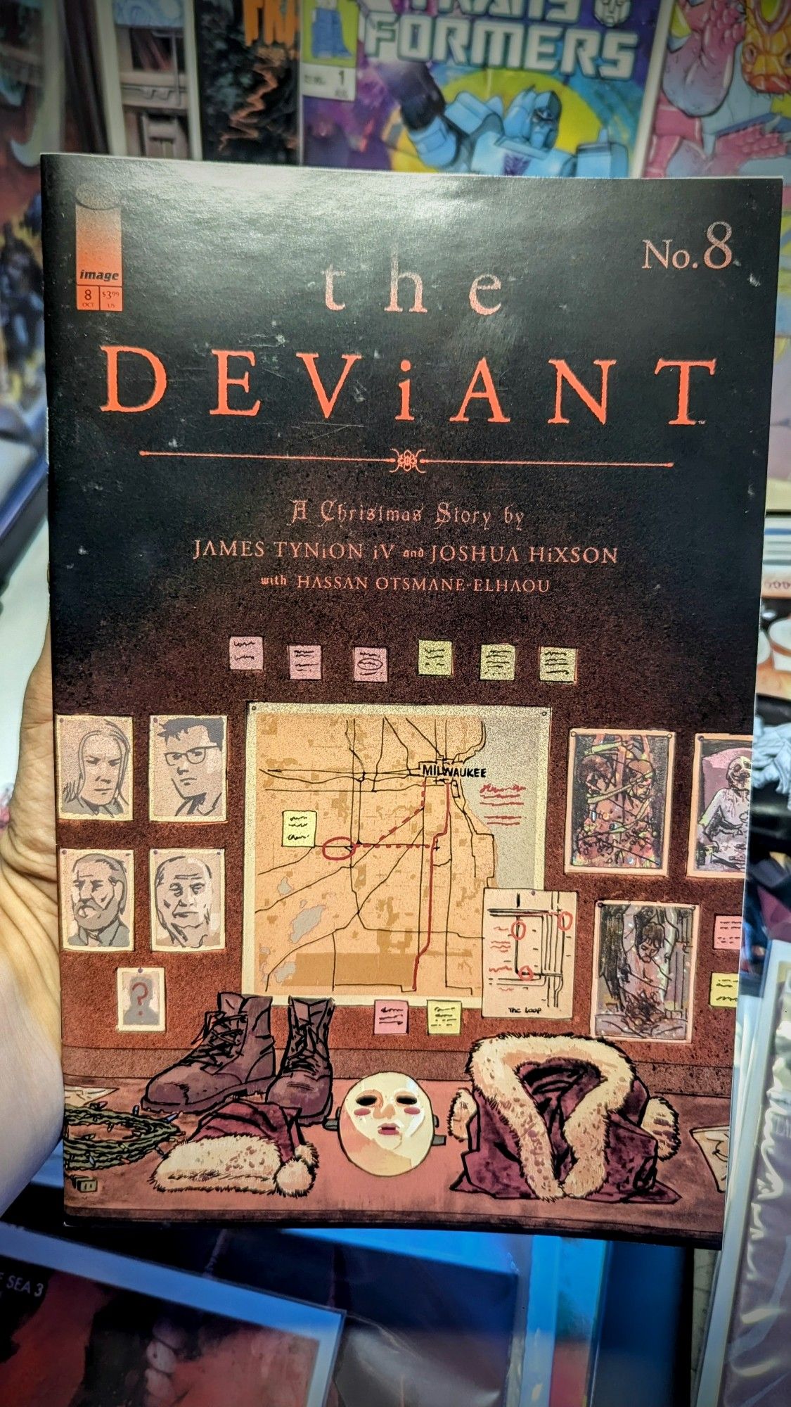 Cover A of The Deviant by Joshua Hixson - Killer Santa suit and boots and pictures of the crimes committed 