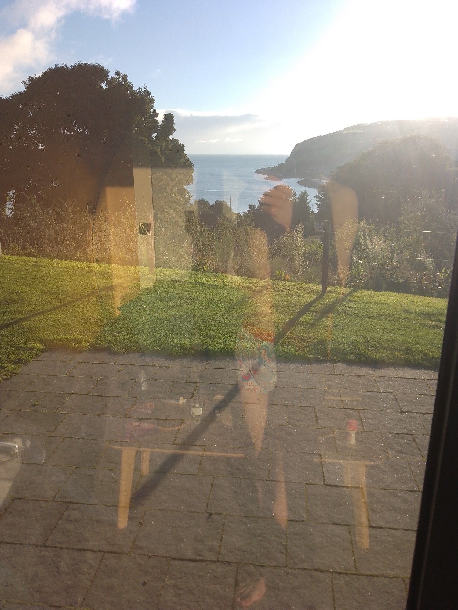 POV of me looking out the glass door of the pod, watching the sun rise over the hill 

Reflection of me standing in my underwear is partially visible