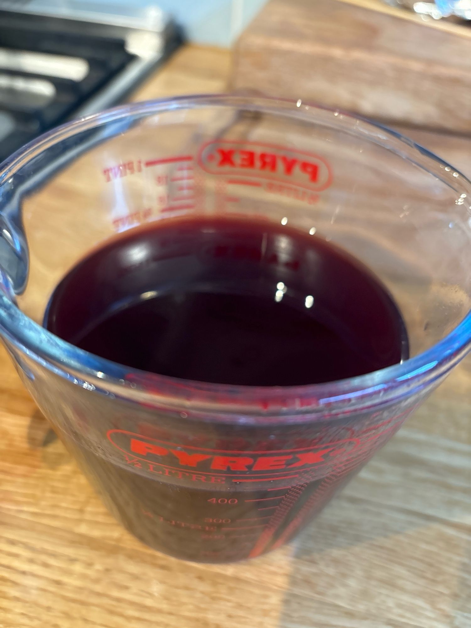 Pyrex jug containing dark red cherry infusion