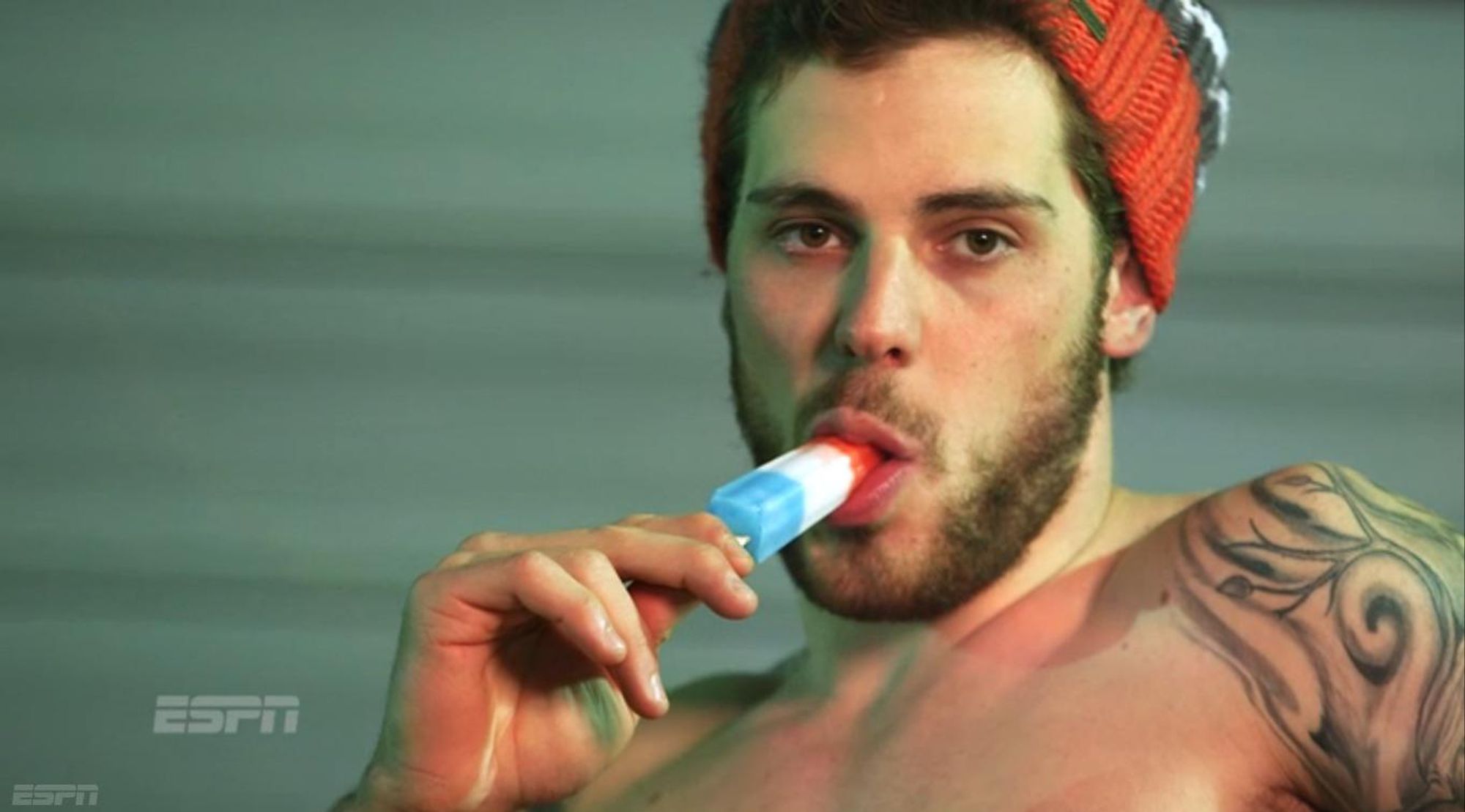 Tyler Seguin of the Dallas Stars, wearing nothing but a touque and his tattoos, looks directly into the camera while mouthing a RocketPop. Picture only shows from just above the nipples up, which is just as well what with the ease of lithuim batteries spontaneously combusting.