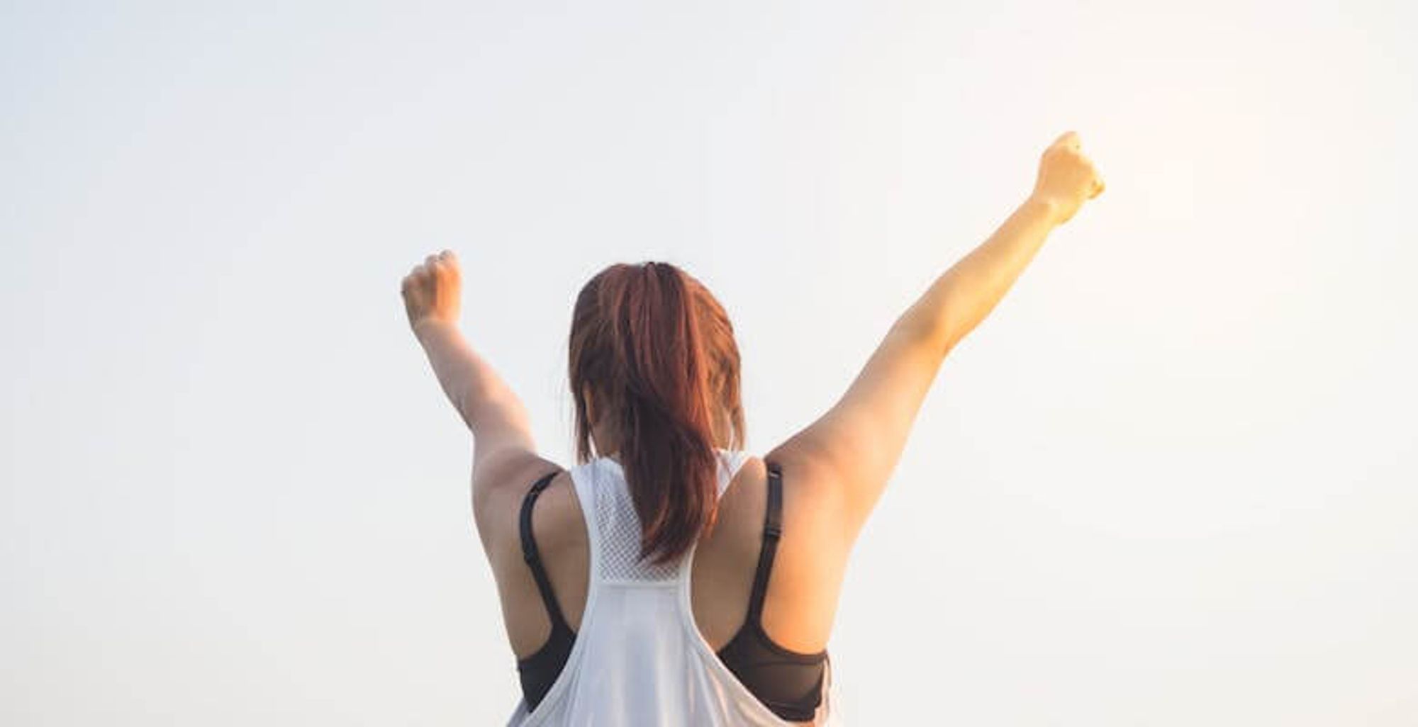 The image depicts a person raising their hands in triumph.