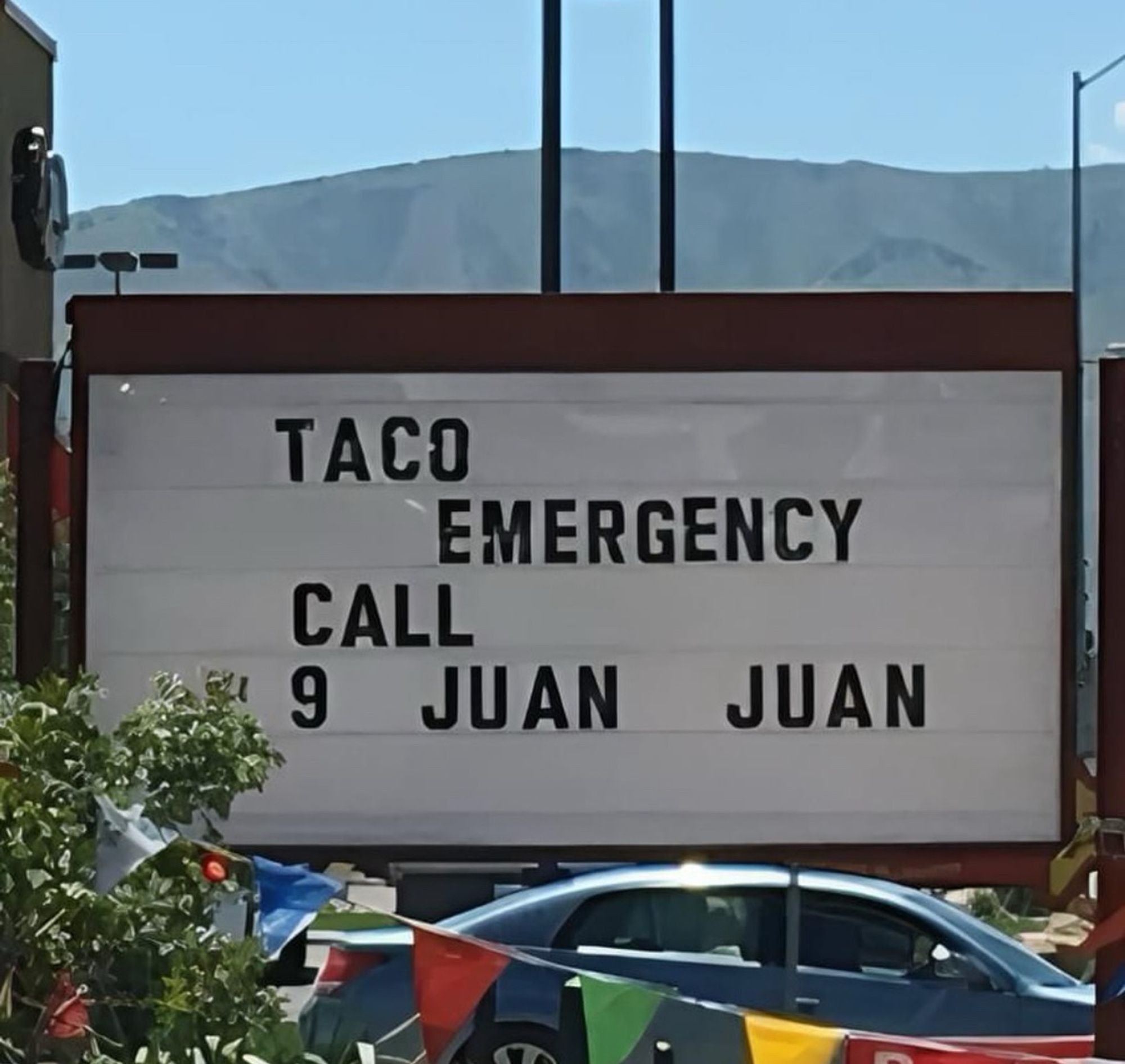 Sign that reads:

TACO
EMERGENCY
CALL
9 JUAN
JUAN