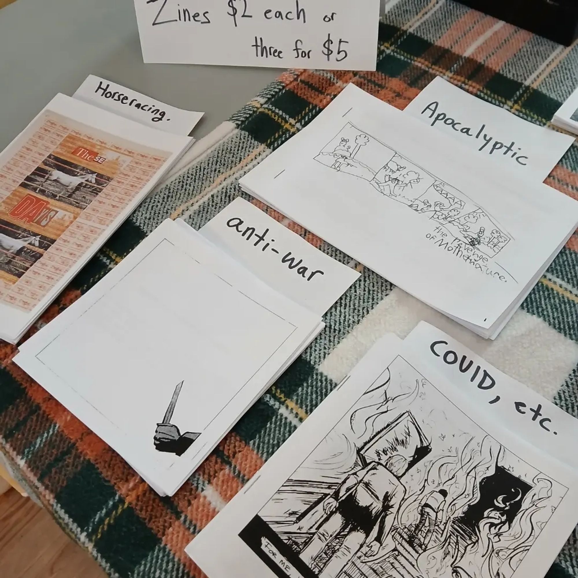 Close up of Covid, anti-war, horseracing and apocalyptic themed zines