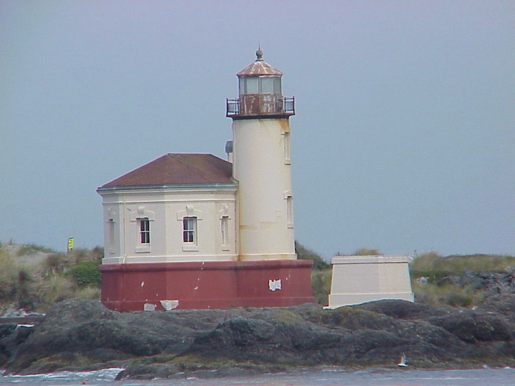 A lighthouse on a pier, surrounded by water.