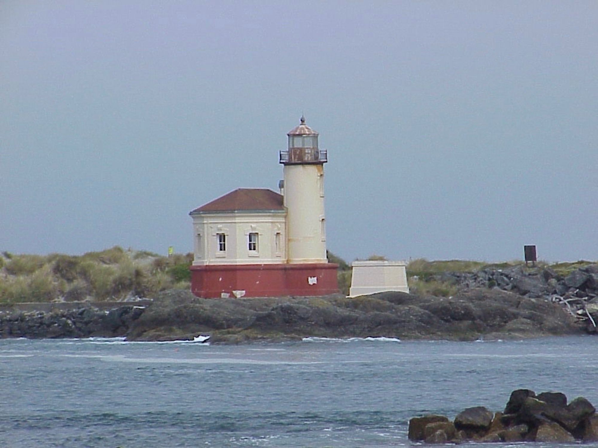 A lighthouse on a pier, surrounded by water.