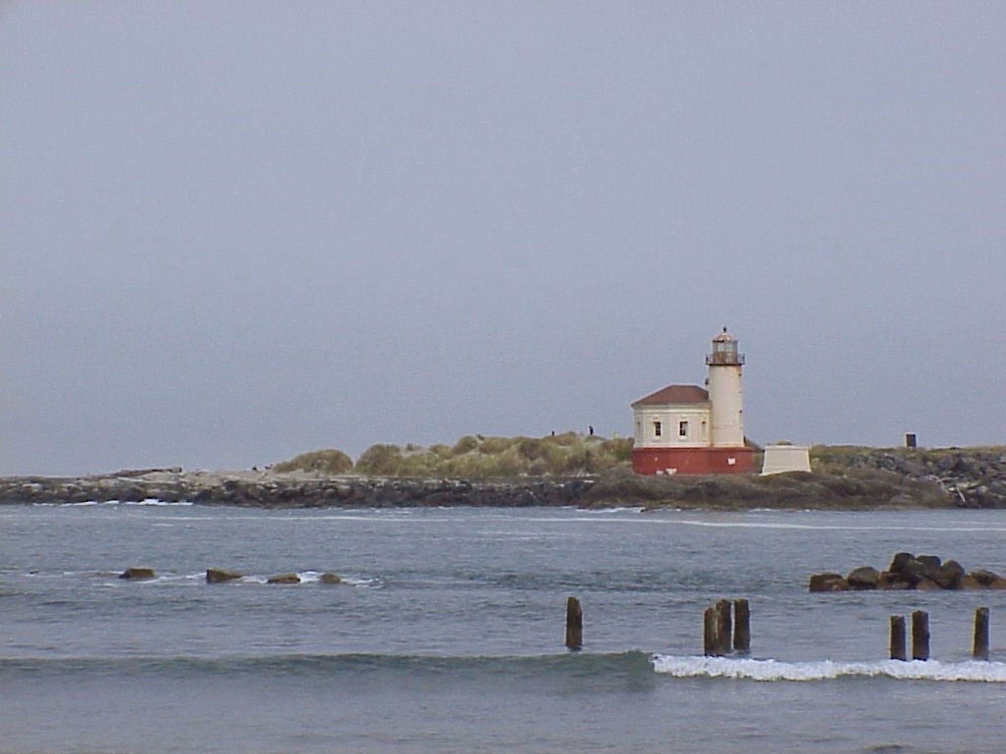 A lighthouse on a pier, surrounded by water.