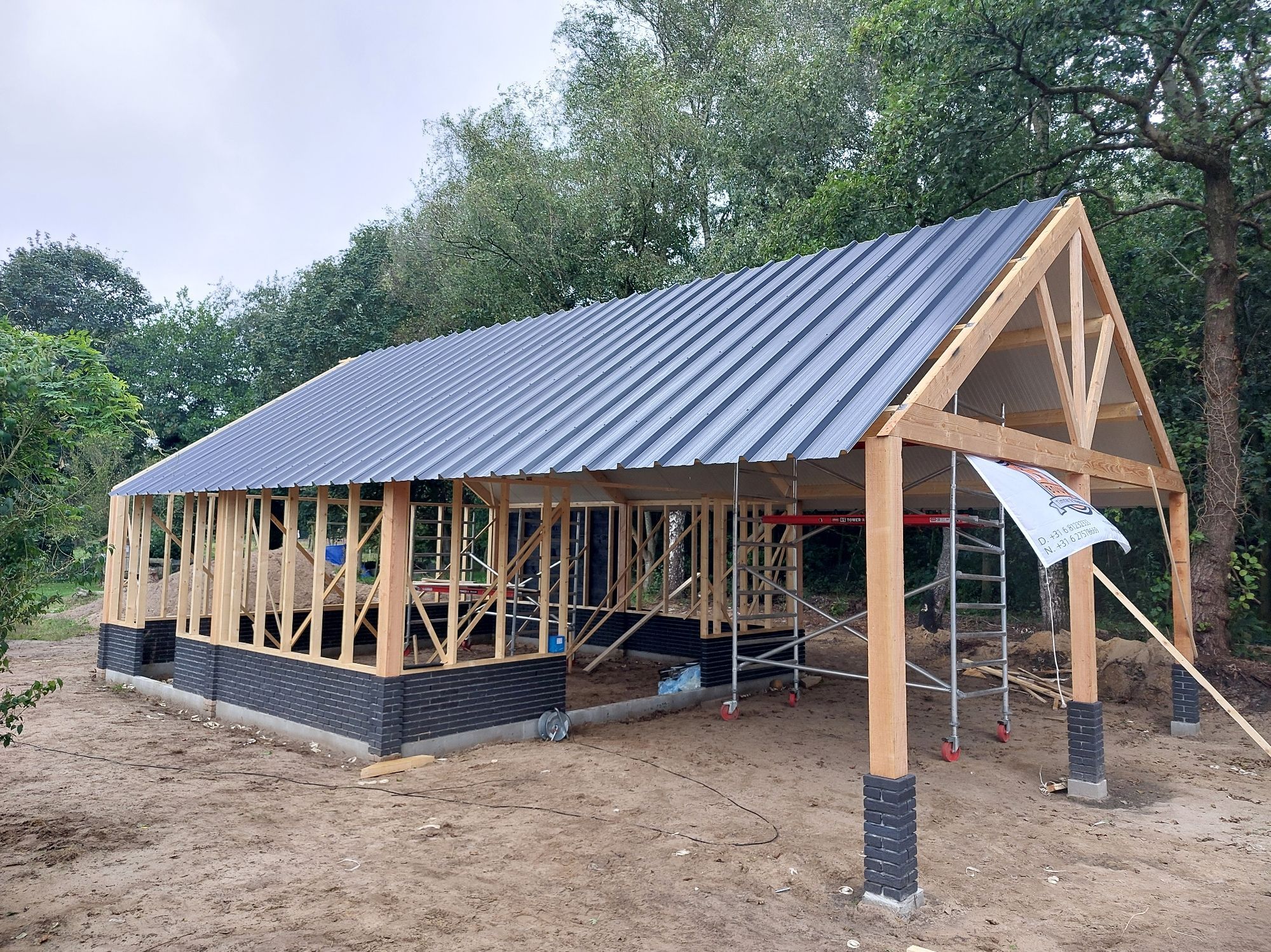 Houten schuur met een zwart stalen dak