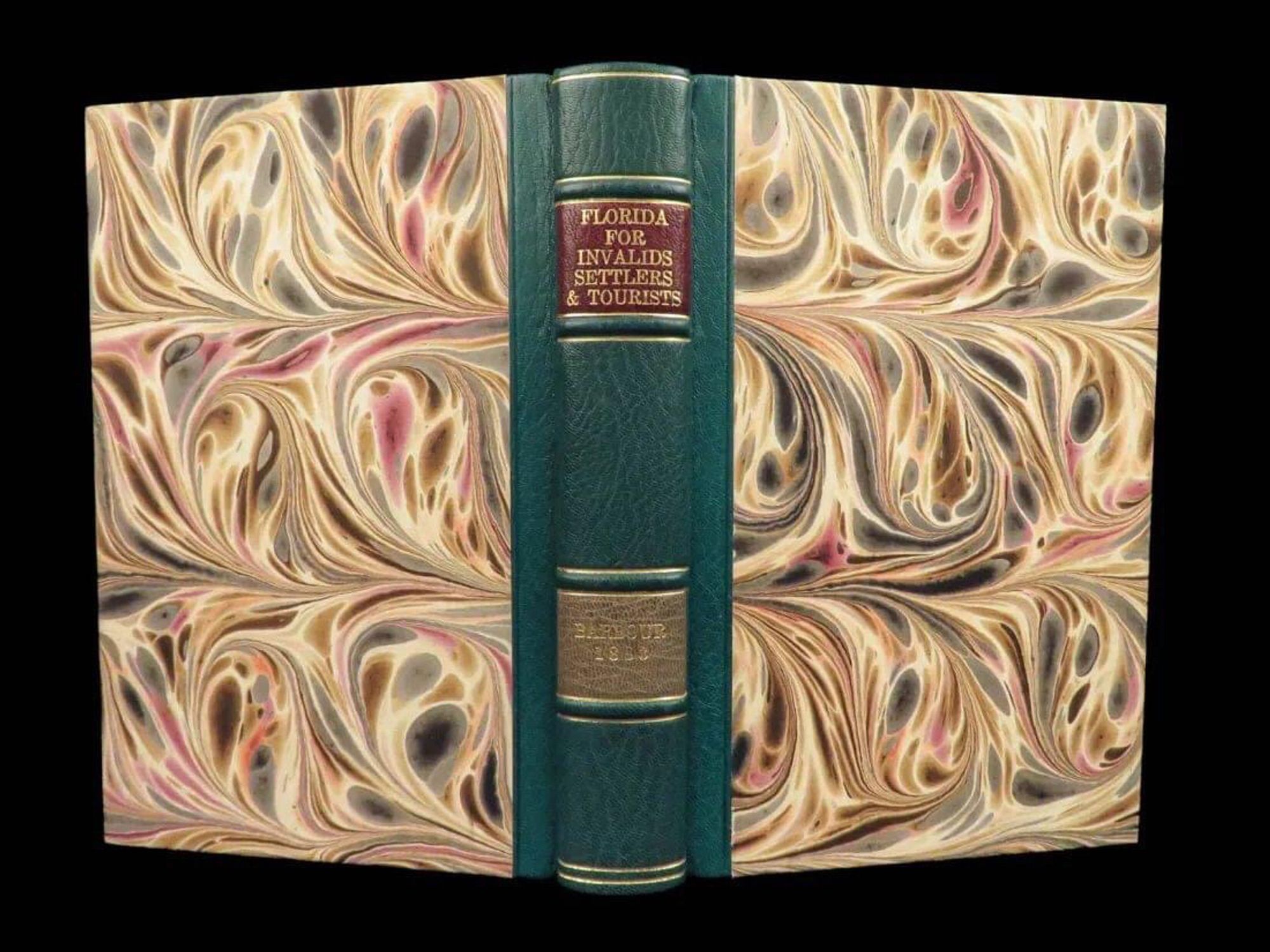 Amazing marbleized book cover with a background of cream and marbled colors of brown, wine, gray. The spine is green-dyed leather.