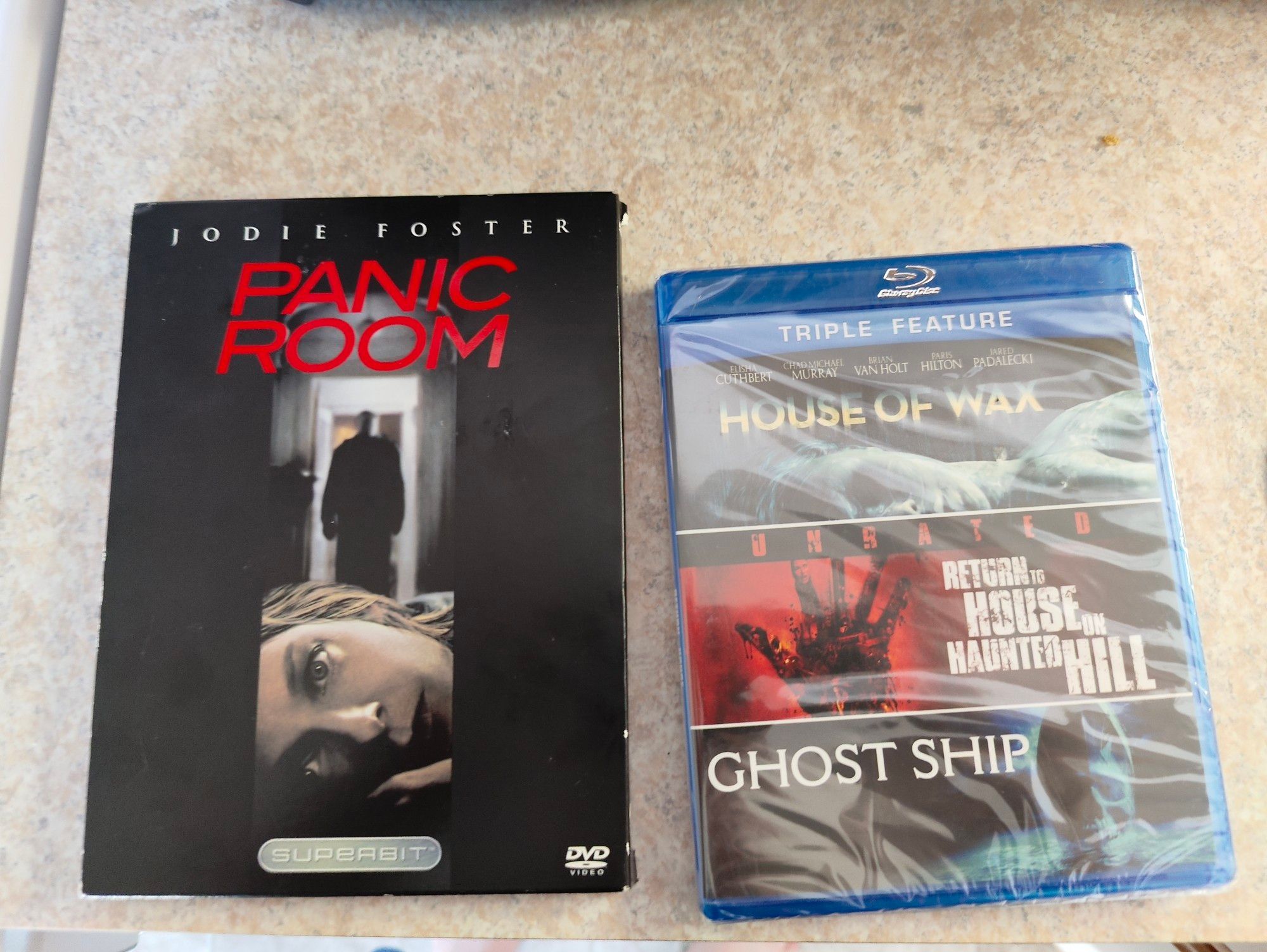 A Superbit DVD of "Panic Room" and a three pack Blu-ray set of "House of Wax", "Return to House on Haunted Hill" and "Ghost Ship".