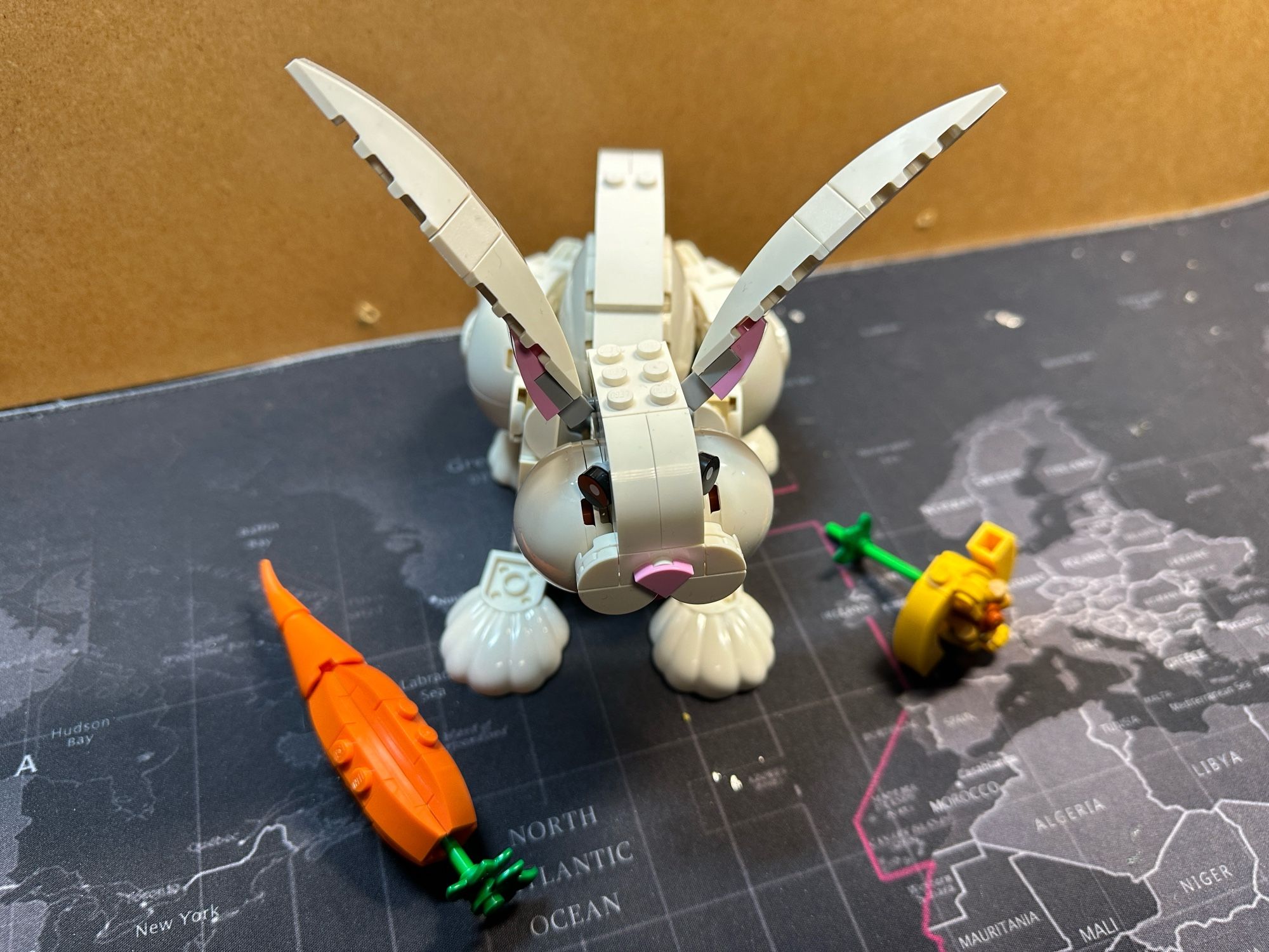 A Lego model of a white bunny with a carrot and something yellow (no idea what it’s supposed to be.)