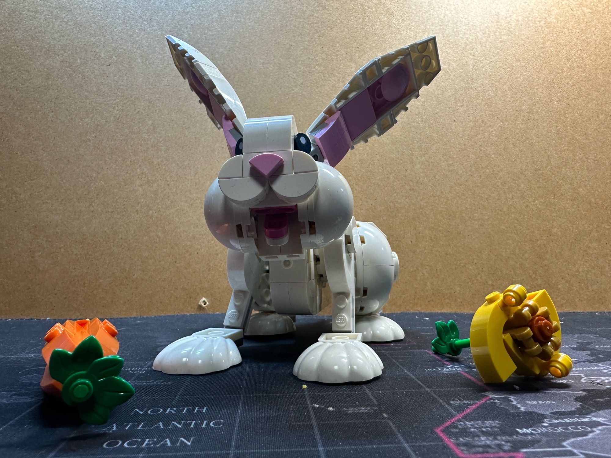 A Lego model of a white bunny with a carrot and something yellow (no idea what it’s supposed to be.)