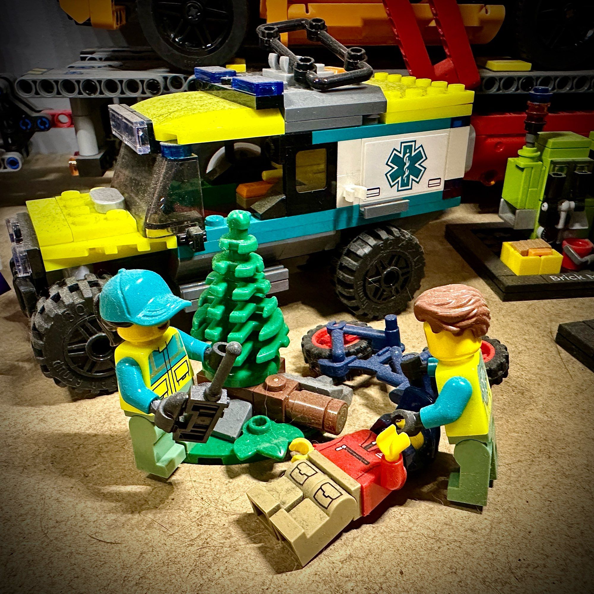 A Lego scene with an off-road ambulance, paramedics, a fallen motorcross bike and a victim.