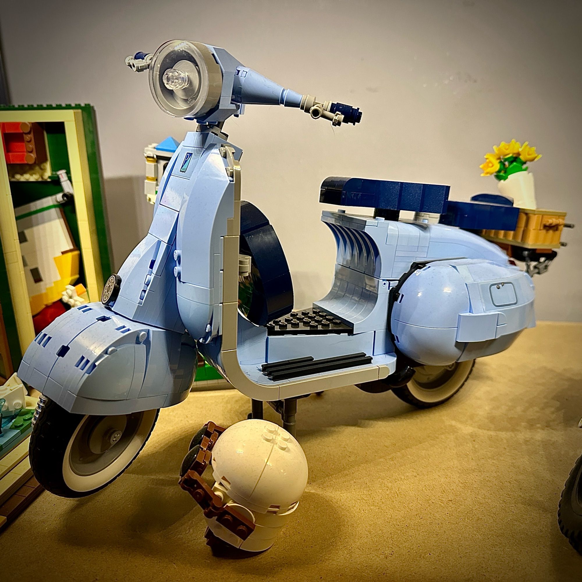 Lego model of a blue-ish Vespa scooter.