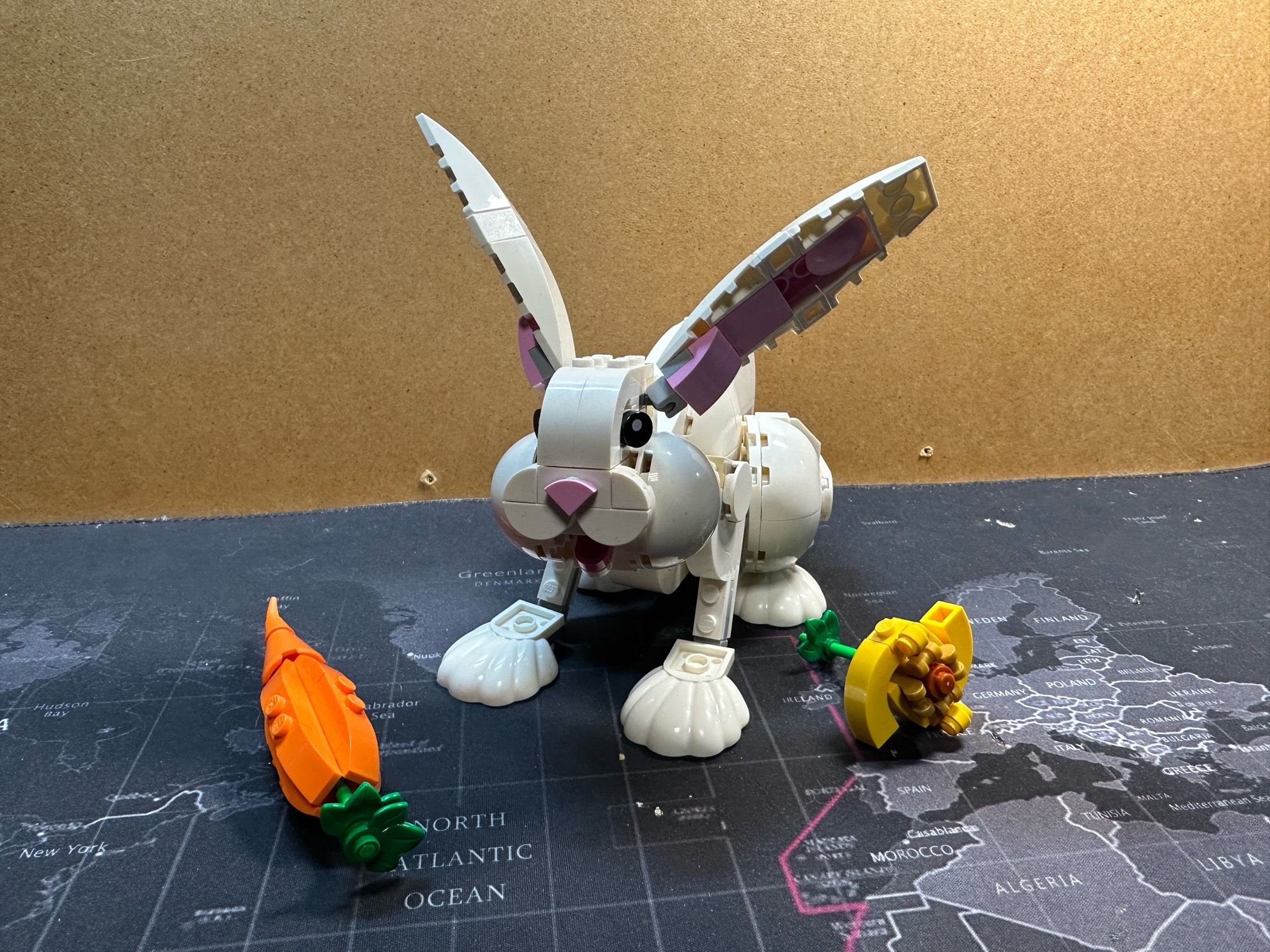 A Lego model of a white bunny with a carrot and something yellow (no idea what it’s supposed to be.)