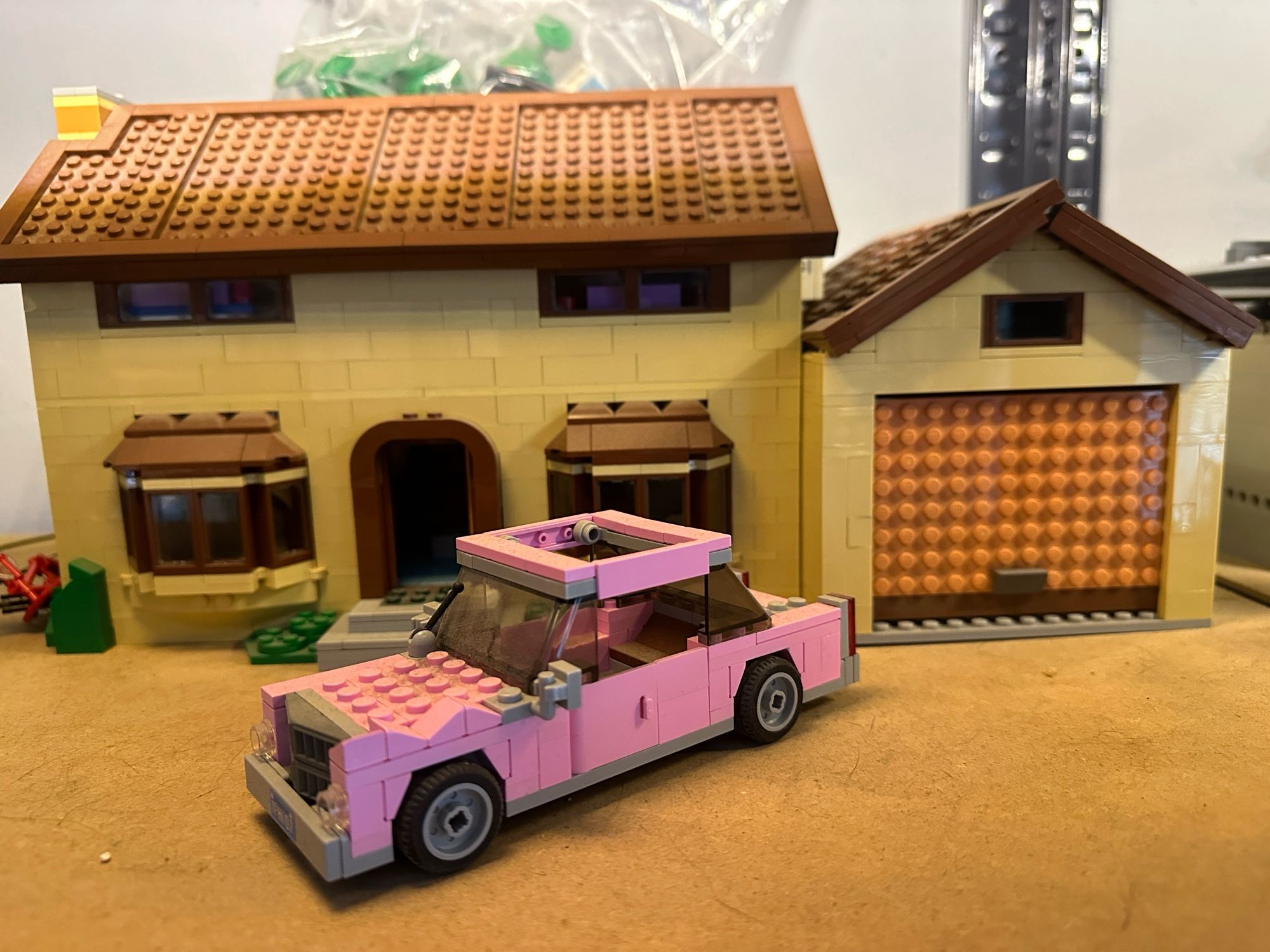 A Lego model of the house from the Simpsons, with Homer’s pink car in front.