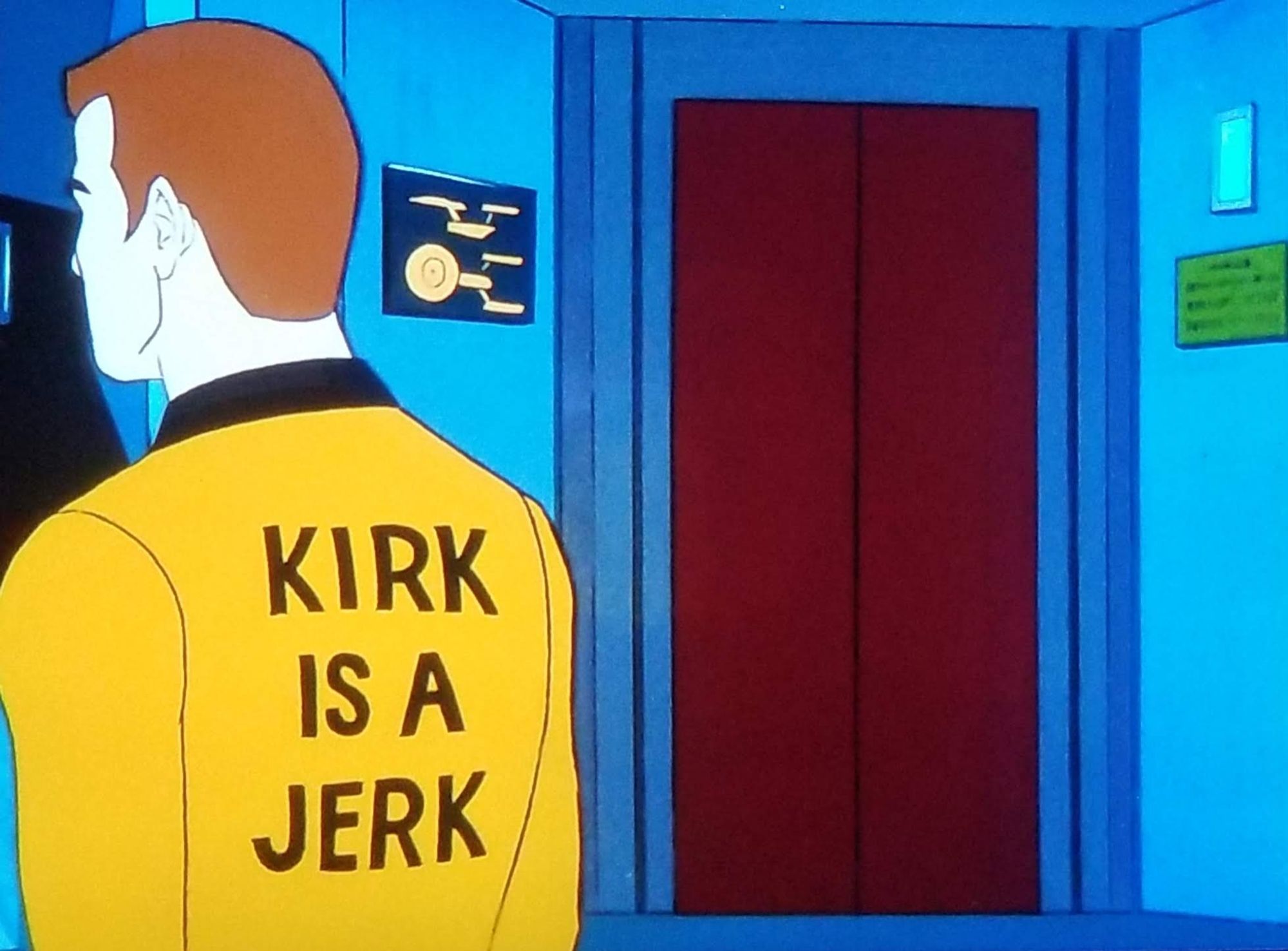 Star Trek The Animated series scene. We're looking at the bridge of the Enterprise, the cartoon version. Standing with his back to us is Captain Kirk in his gold uniform. The back of his uniform has a message written on it that reads, "KIRK IS A JERK."